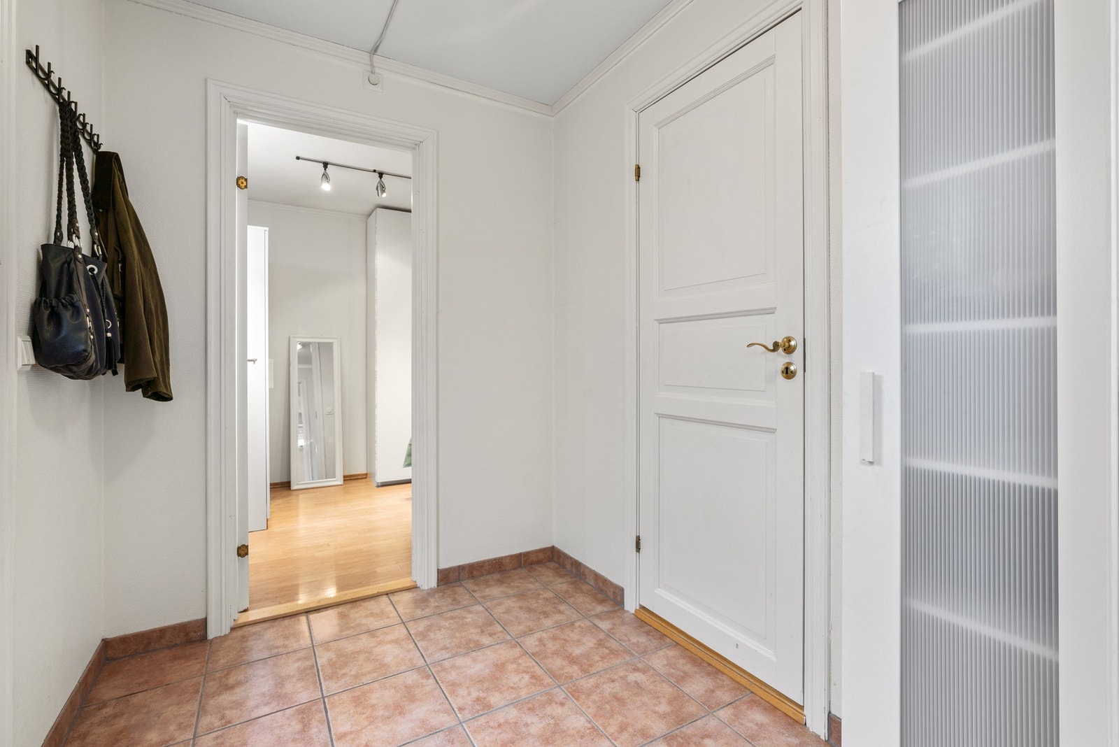 Det er egen inngang til kjelleretasjen. Gangen har garderobeskap og oppheng for jakker. Varmekabler i gulv Galleribilde