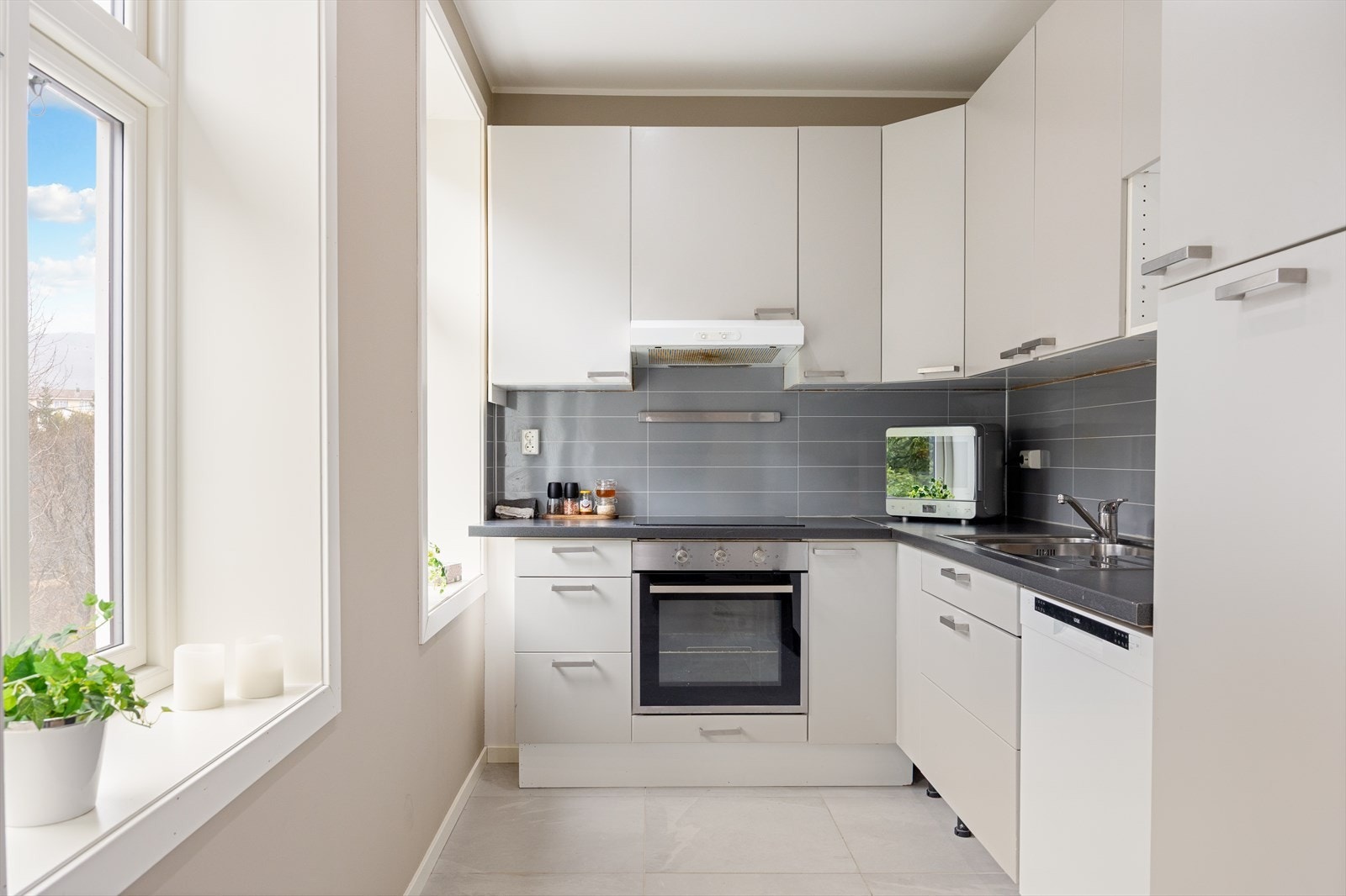 Kjøkken med integrert komfyr, koketopp og oppvaskmaskin Galleribilde