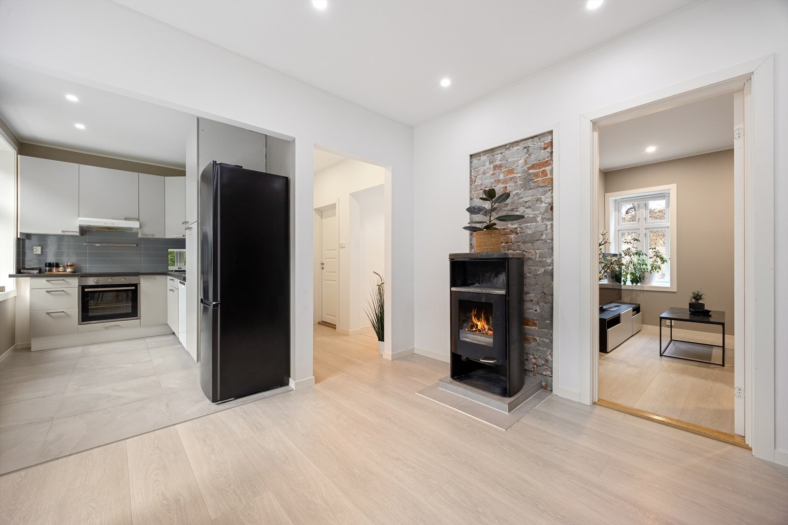 Flott stue med åpen løsning mot kjøkken - Peisovn - Downlights i takhimling Galleribilde