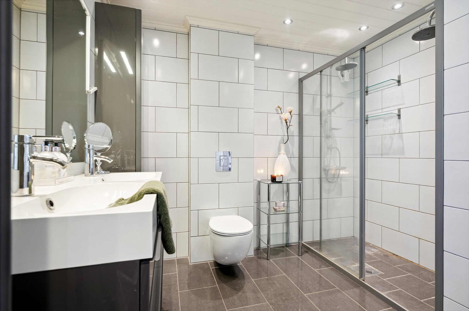Badet har flislagte vegger og gulv, samt en stor dobbel dusj. Galleribilde