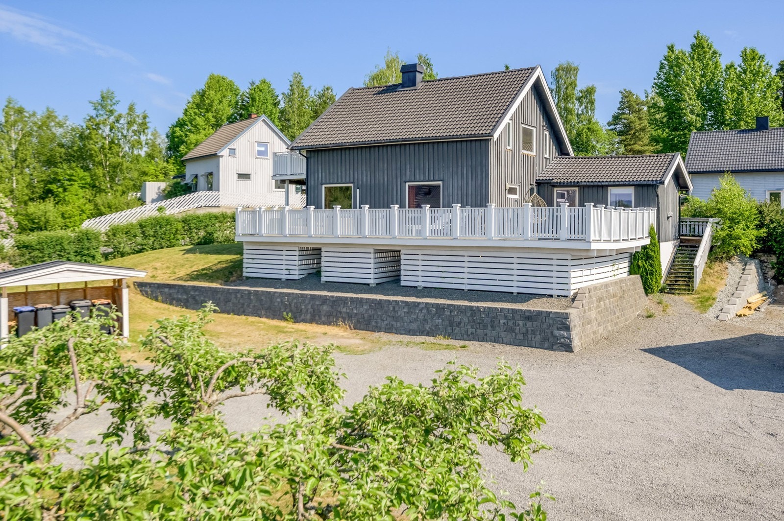 Solrike uteplasser med terrasse på forsiden av boligen. Galleribilde