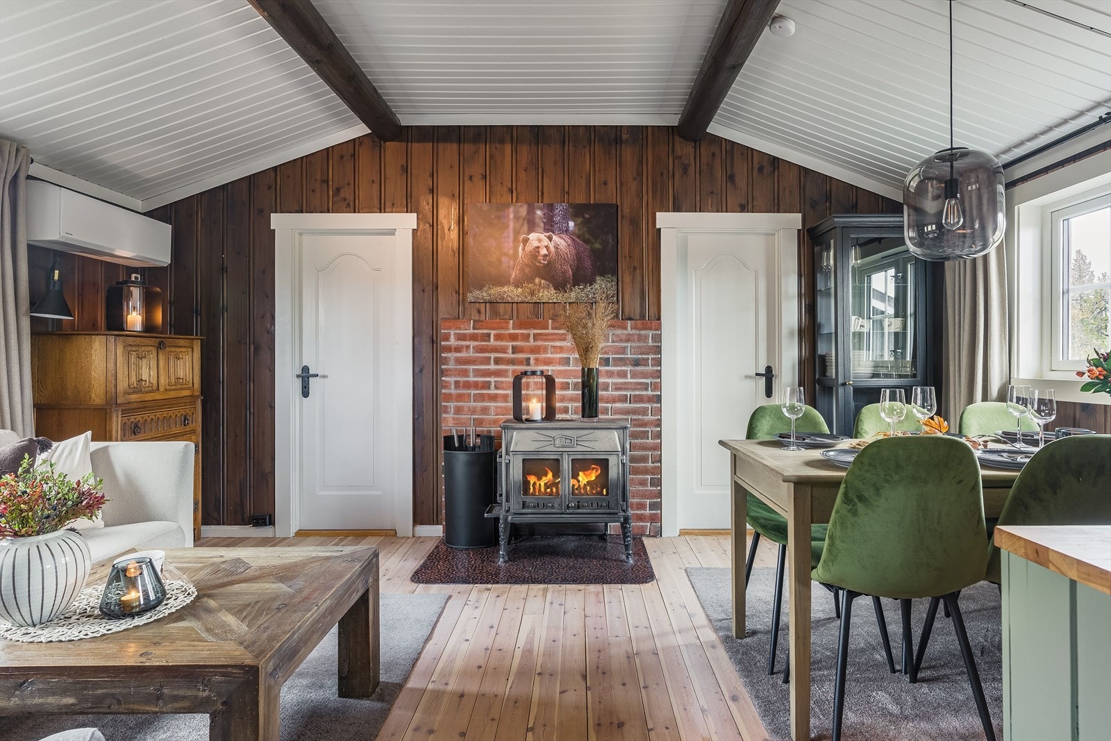 Vedfyring i stuen sikrer jevn varme og bidrar til et komfortabelt innemiljø. Nye 3 lags glass vinduer fra 2024. Galleribilde