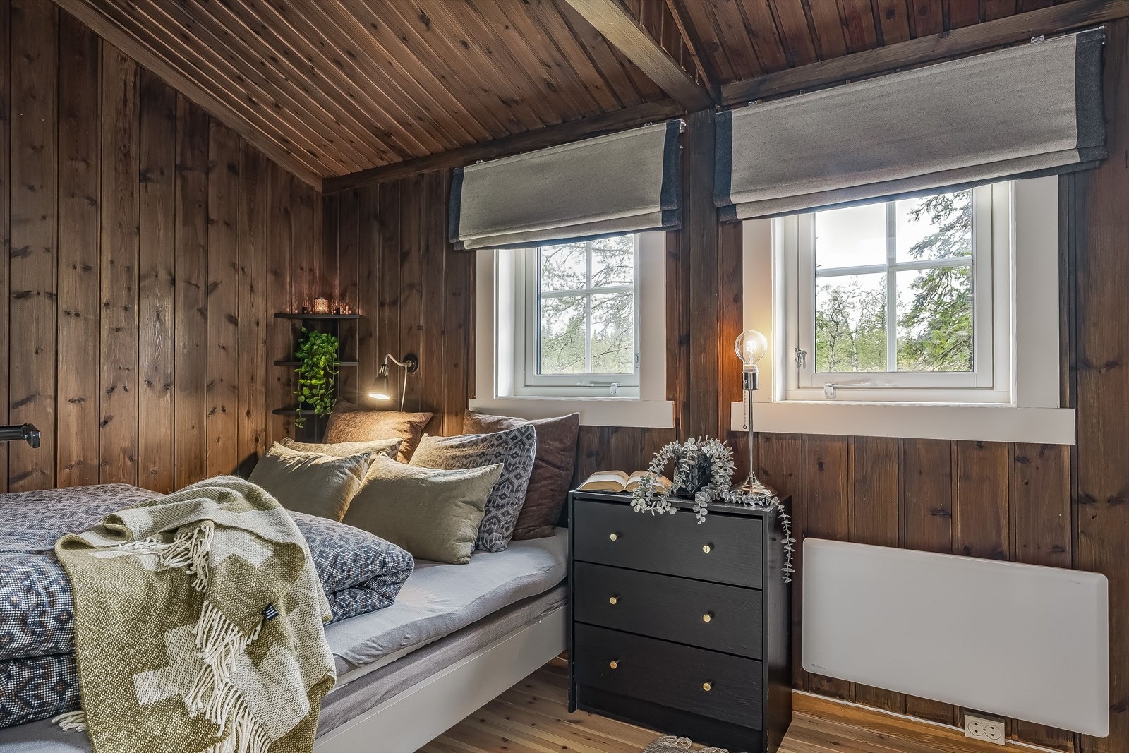 Soverom 2 har trepanel på vegger og tak, som gir et naturlig preg. Vinduene er nylig skiftet i 2024, og har trelags glass for god isolasjon. Galleribilde