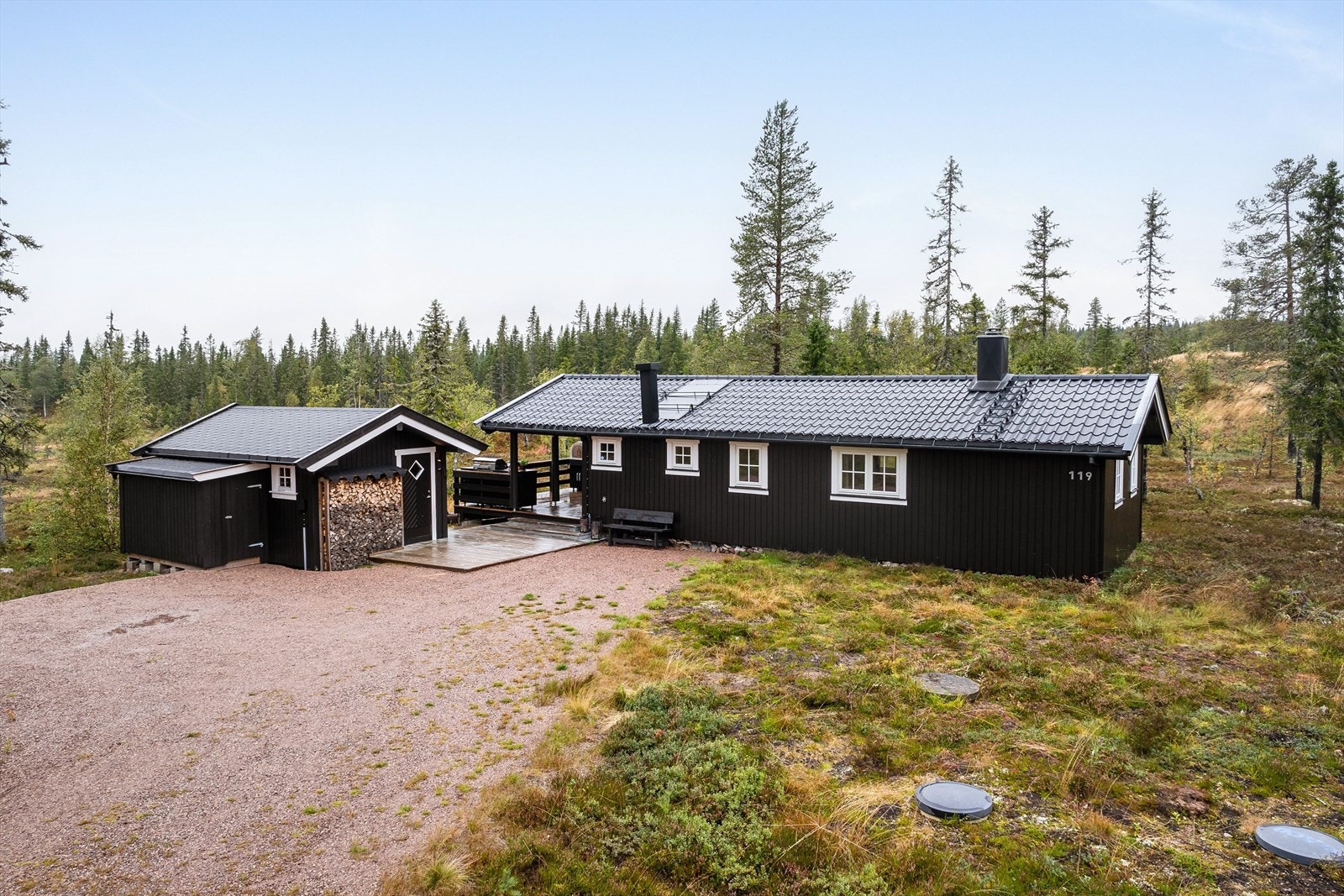Fritidsboligen har en saltakskonstruksjon tekket med stålplater og er utstyrt med takrenner av metall. Galleribilde