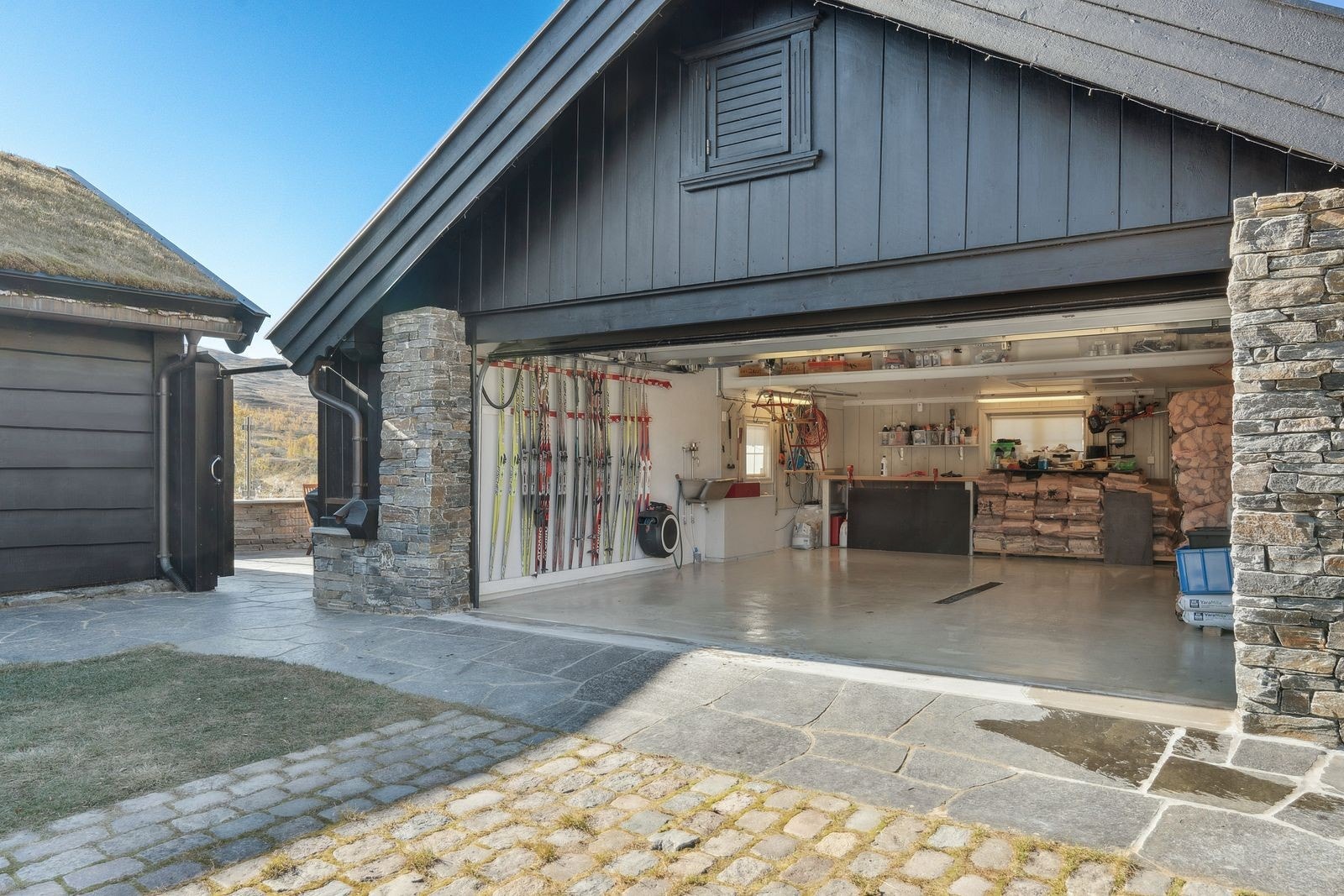 Stor, dobbel frittstående garasje. Dør også inn fra baksiden. Med strøm, innlagt vann og bergvarme i gulvet Galleribilde