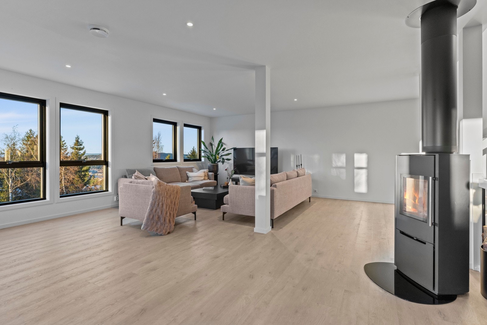 Sentralt i stuen er det plassert en peisovn som gir god varme på kjøligere dager. Galleribilde