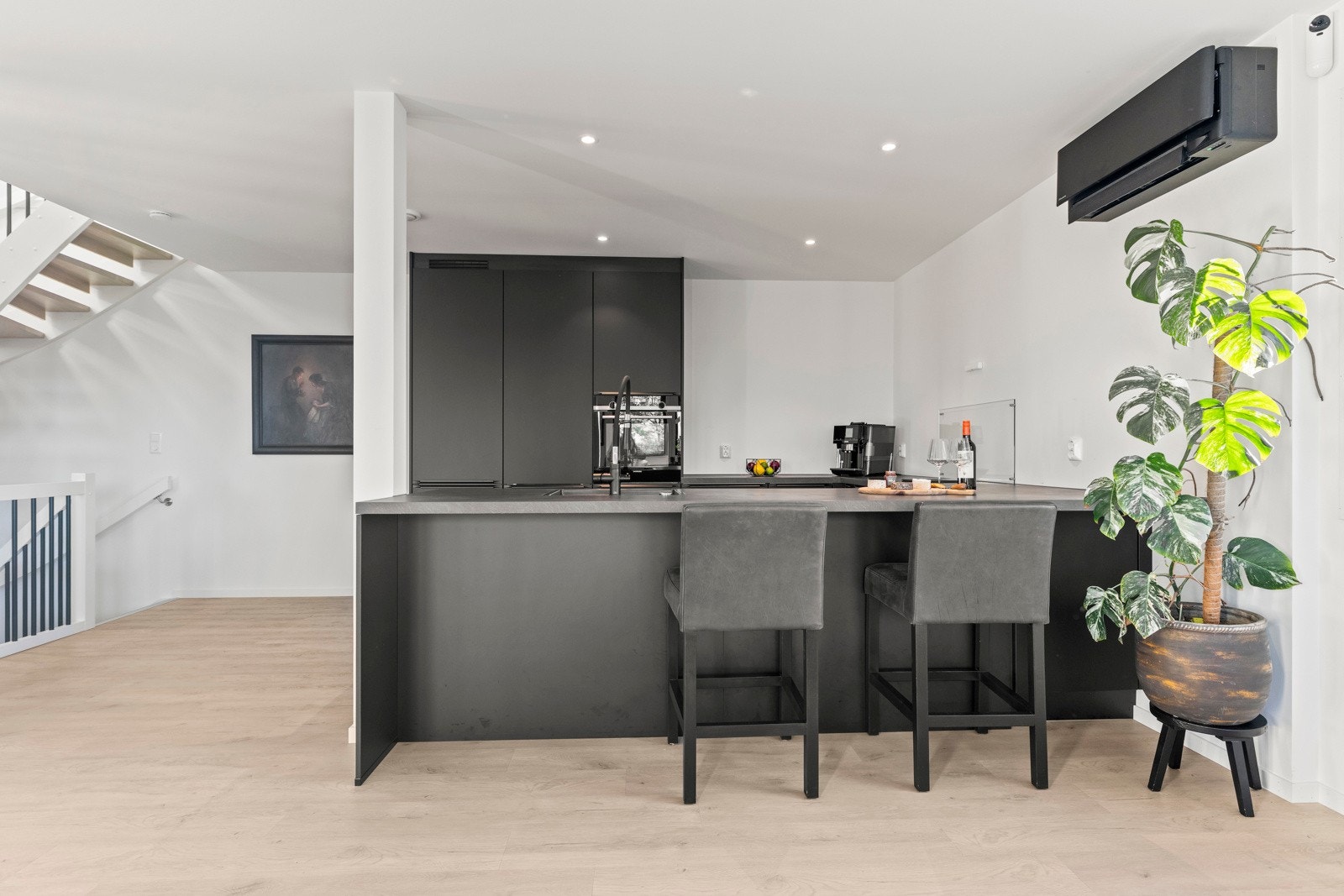 Innbydende og pent kjøkken fra 2023 med sorte, glatte fronter. Galleribilde