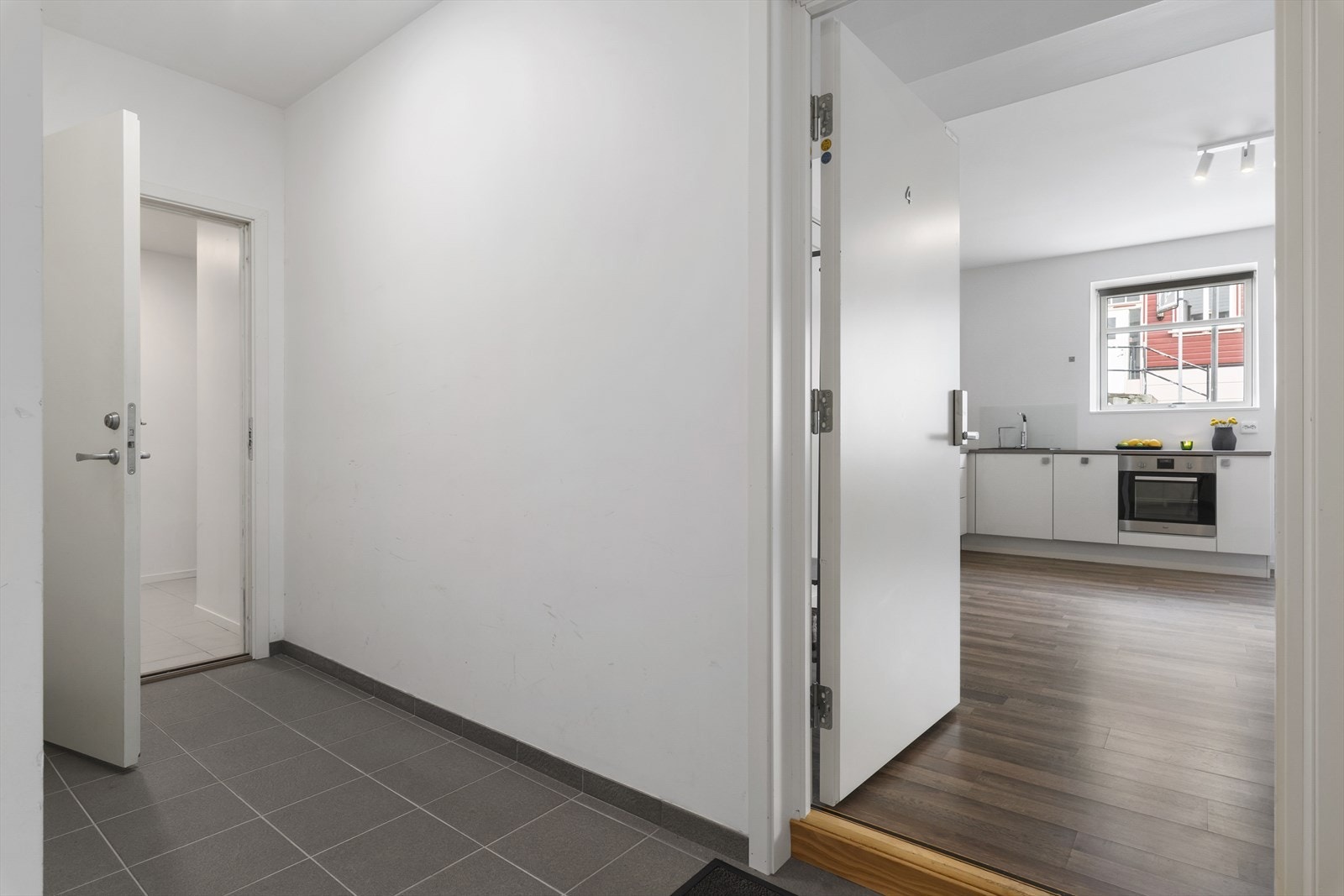 Her kommer vi inn i en flislagt gang før vi går inn i selve leiligheten. Galleribilde