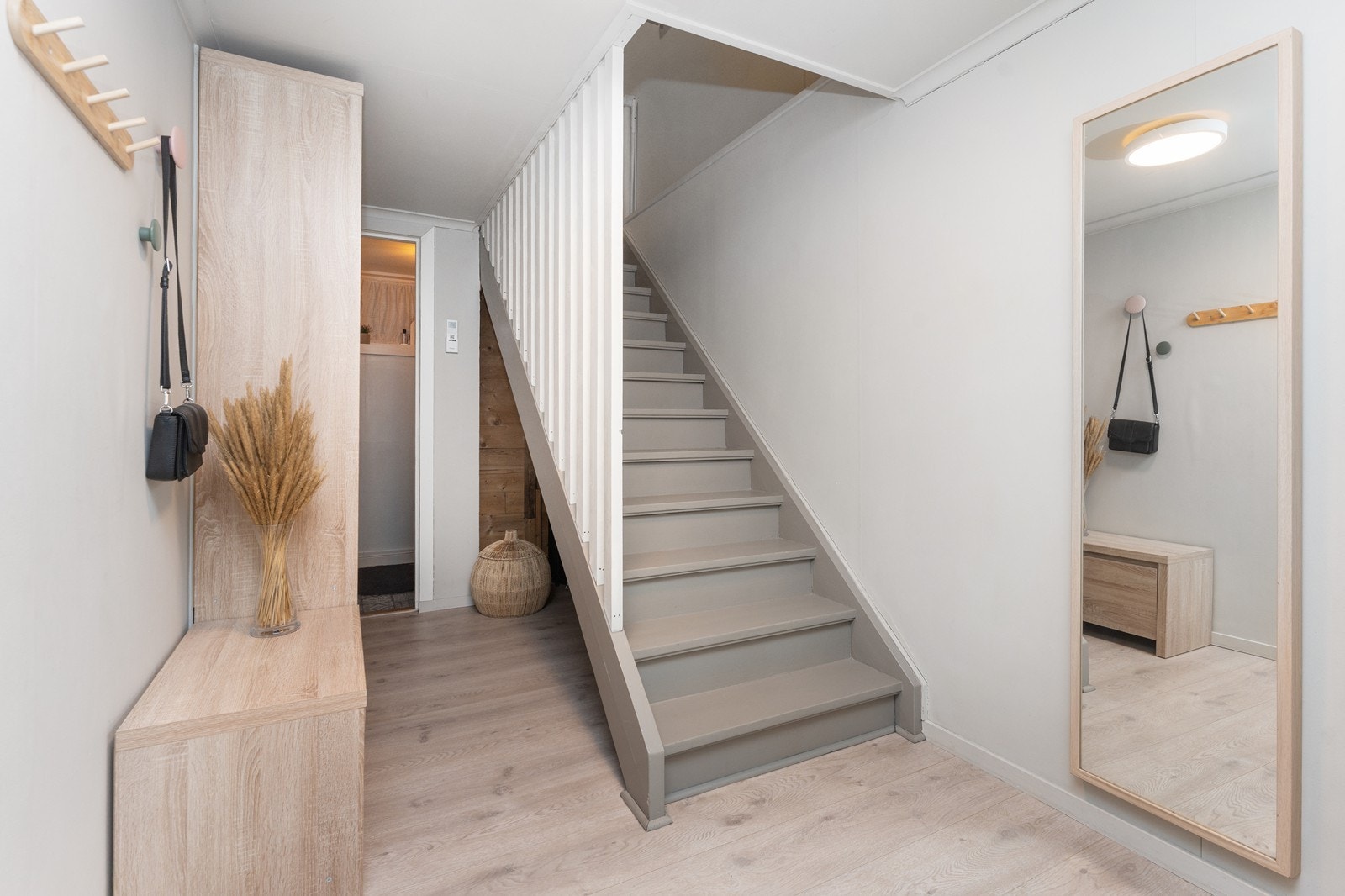 Lys gang med varmepumpe under trapp, videre inn er toalettrom Galleribilde