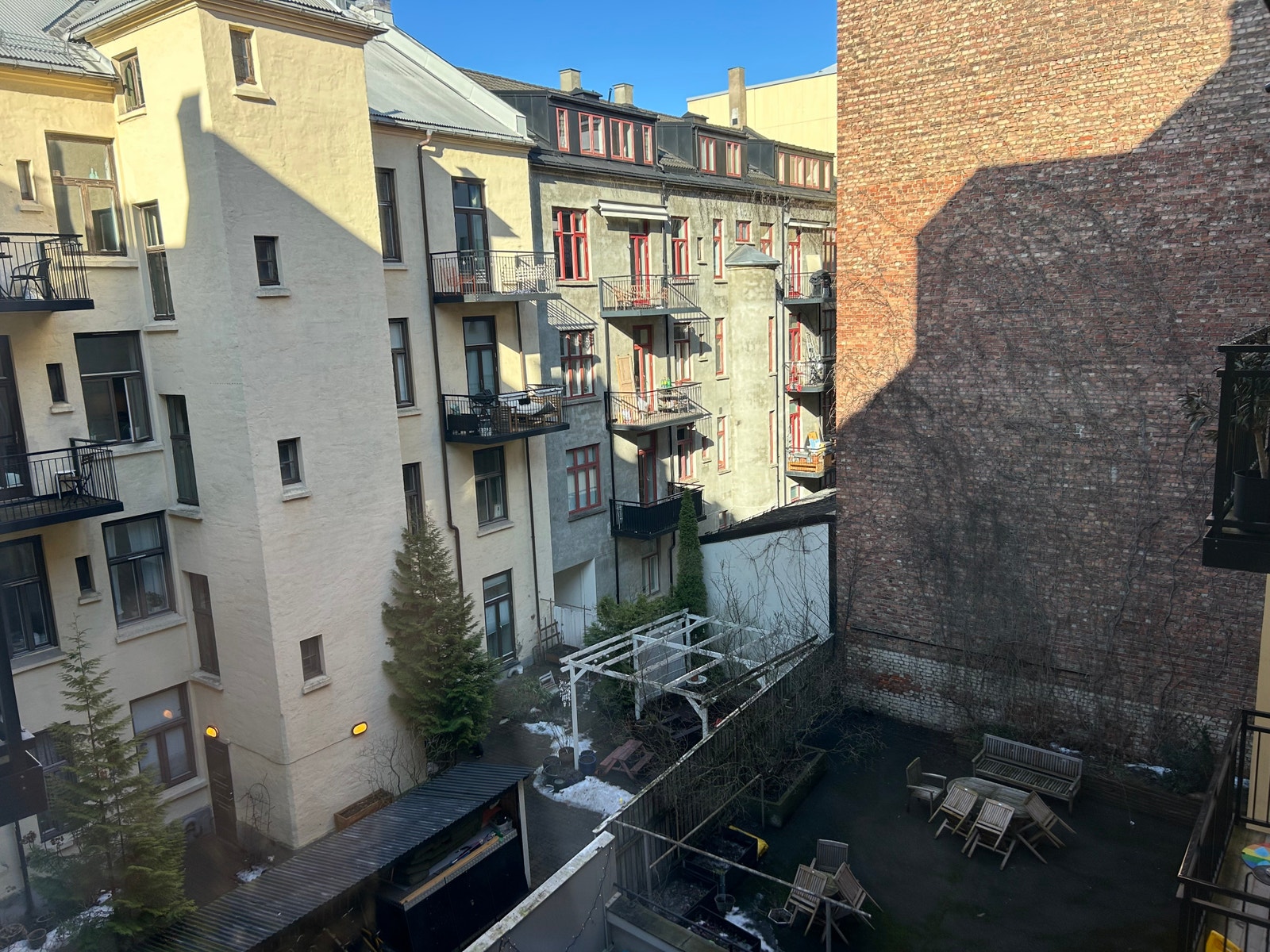 Fransk balkong mot åpen, fredelig og koselig bakgård. Galleribilde