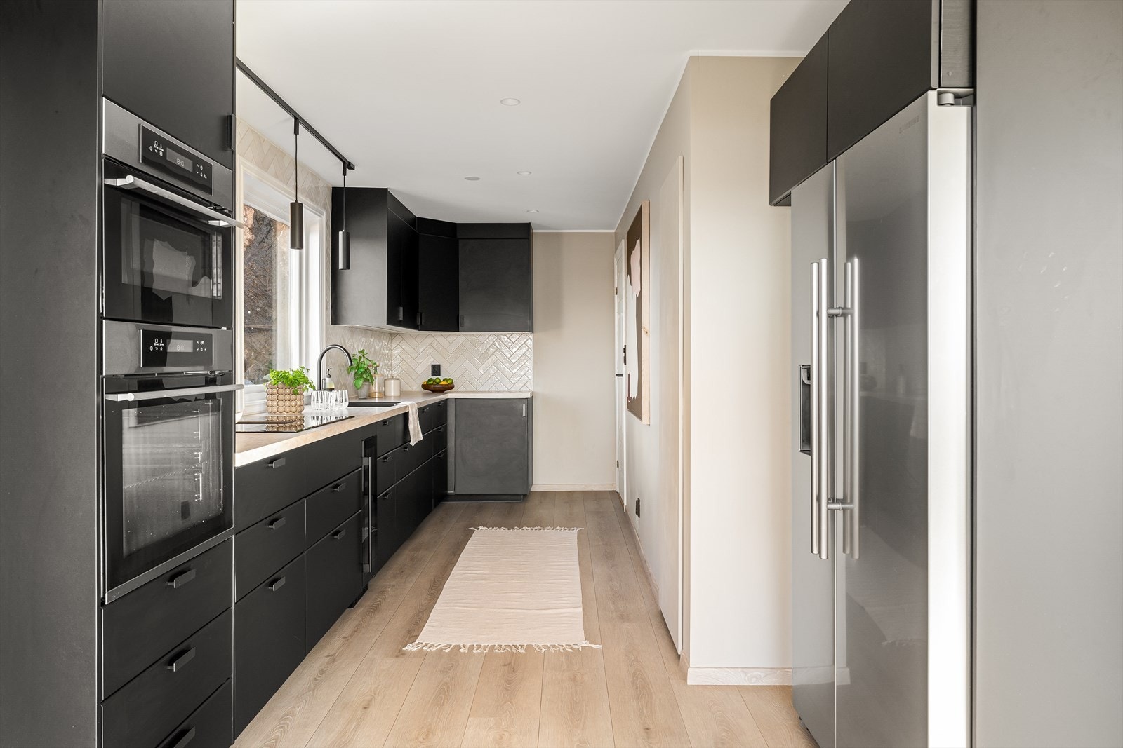 Integrerte hvitevarer inkludert stekeovn, mikrobølgeovn, platetopp, oppvaskmaskin og vinskap. Galleribilde