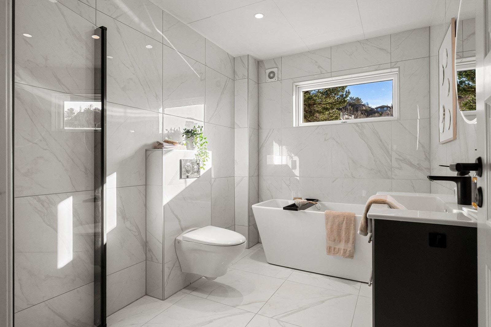 Moderne bad fra 2021 med helfliset finish og store vinduer som slipper inn rikelig med naturlig lys. Galleribilde