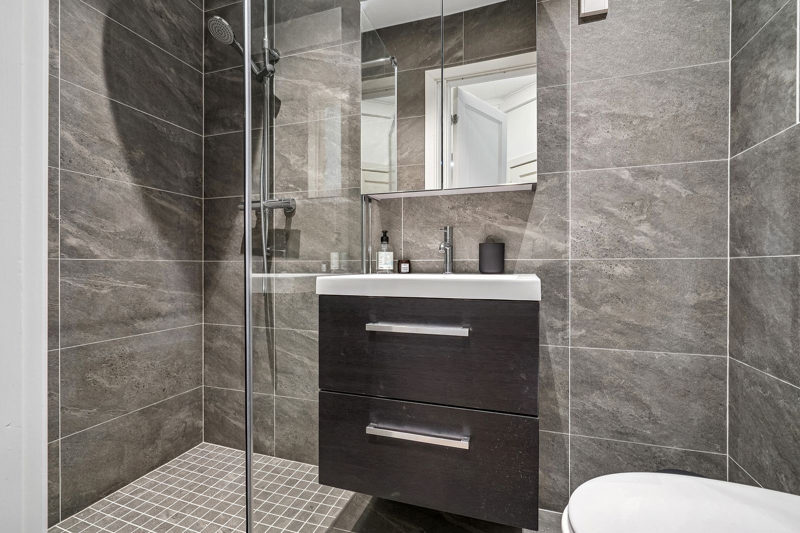 Pent bad med dusjhjørne, servant med underskuffer, wc og vaskemaskin. Varme i gulv. Galleribilde