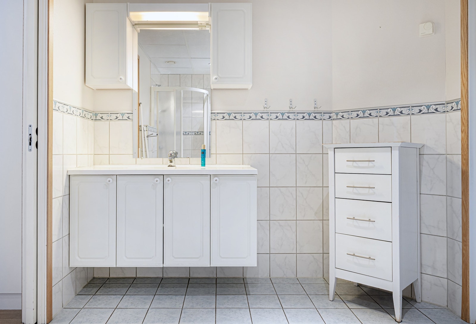 Baderomsinnredning med nedfelt servant og god oppbevaringsplass i skap. Galleribilde