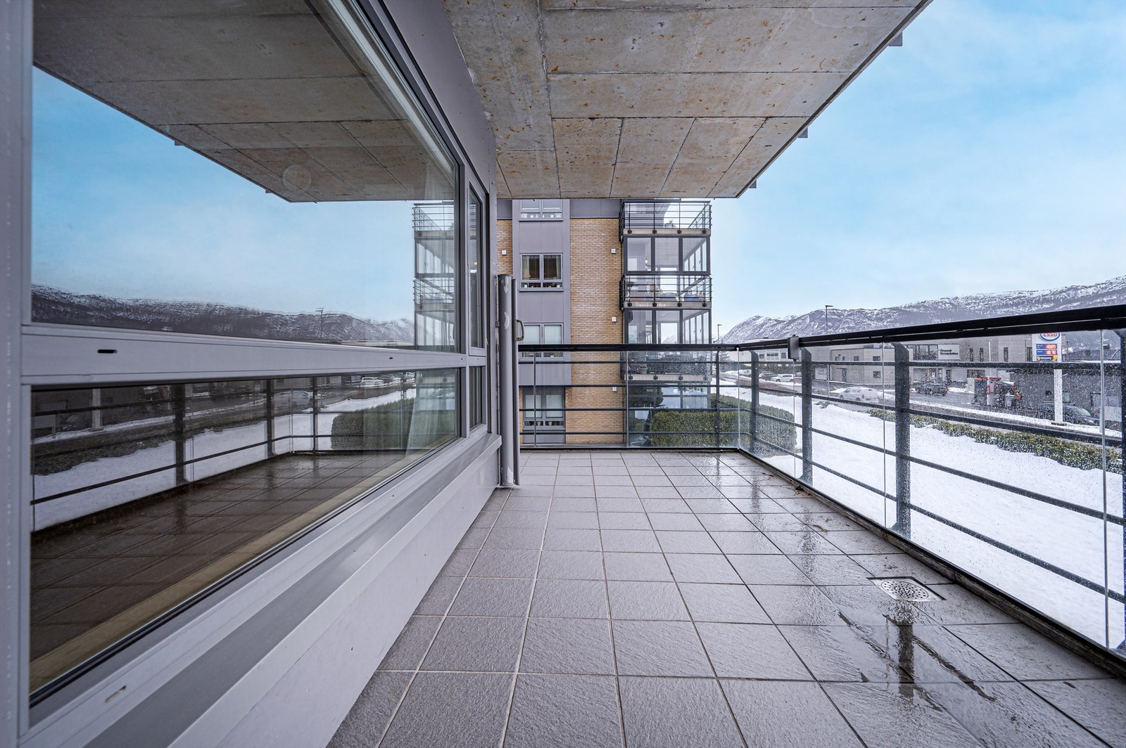 Fra stuen er det direkte utgang til en stor terrasse på 14 m² med rekkverk av stål og glass Galleribilde