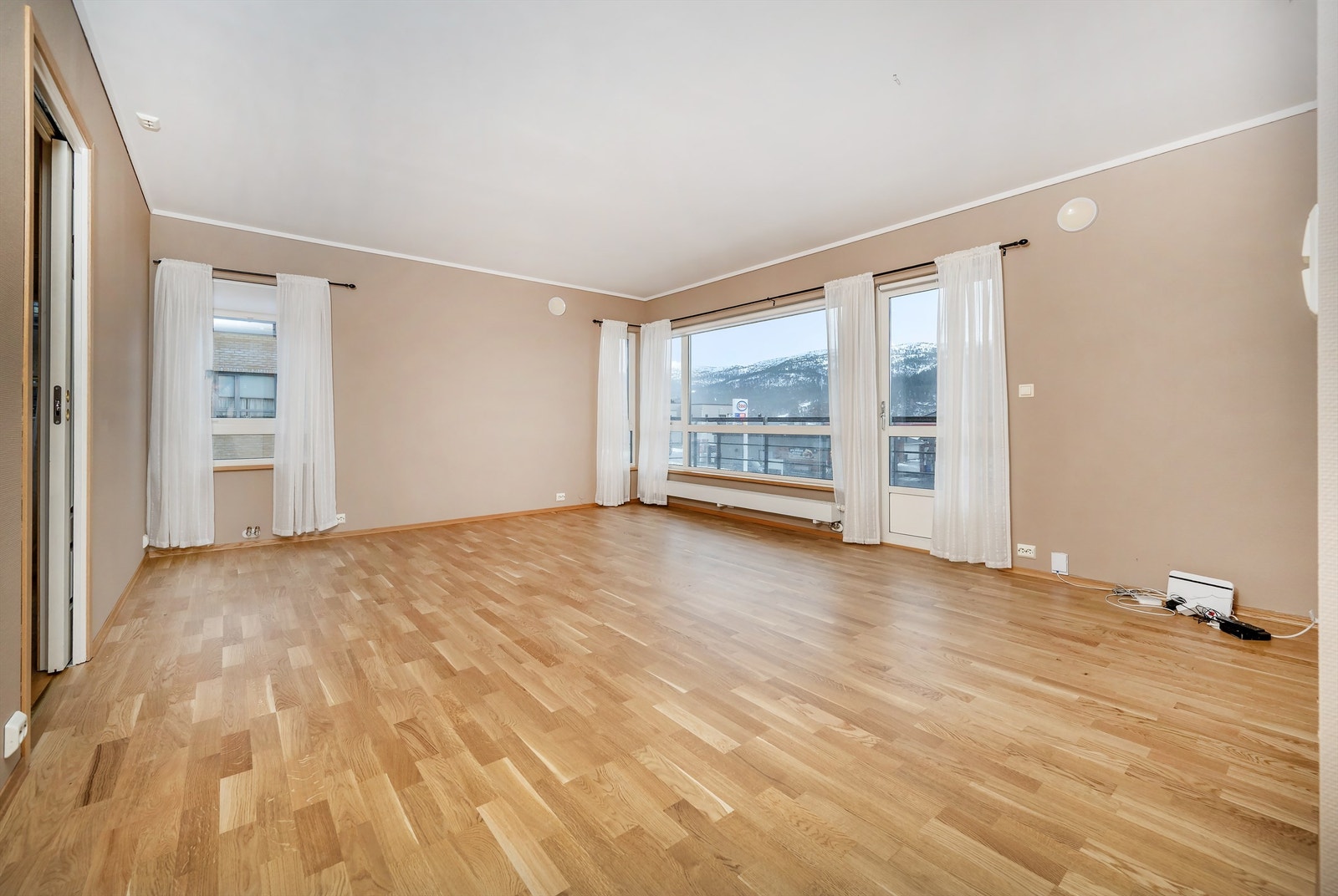 Romslig stue med store vindusflater og ny parkett lagt i 2025 Galleribilde