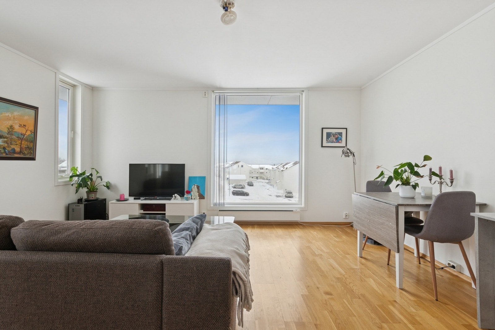 Lys og romslig stue med store vinduer, parkettgulv og flott utsikt Galleribilde