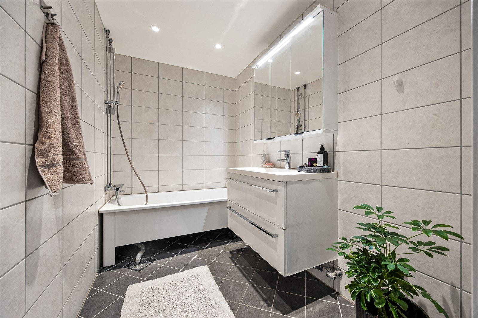 Det flislagte badet har varmekabler i gulvet for økt komfort. Galleribilde