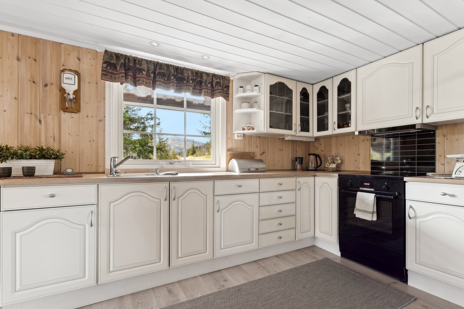 Det er godt med skap og benkeplass på kjøkkenet. Overskapene går helt opp til taket. Galleribilde