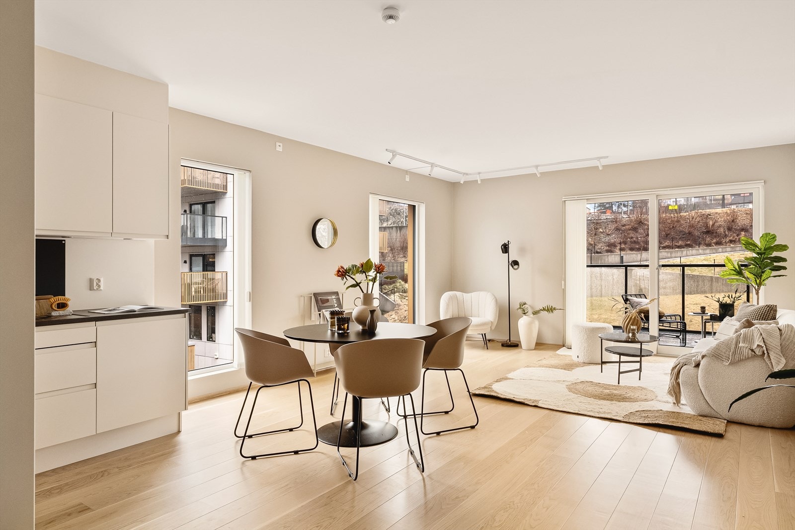 Stor lys stue med enstavs parkett og utgang til altan. Galleribilde