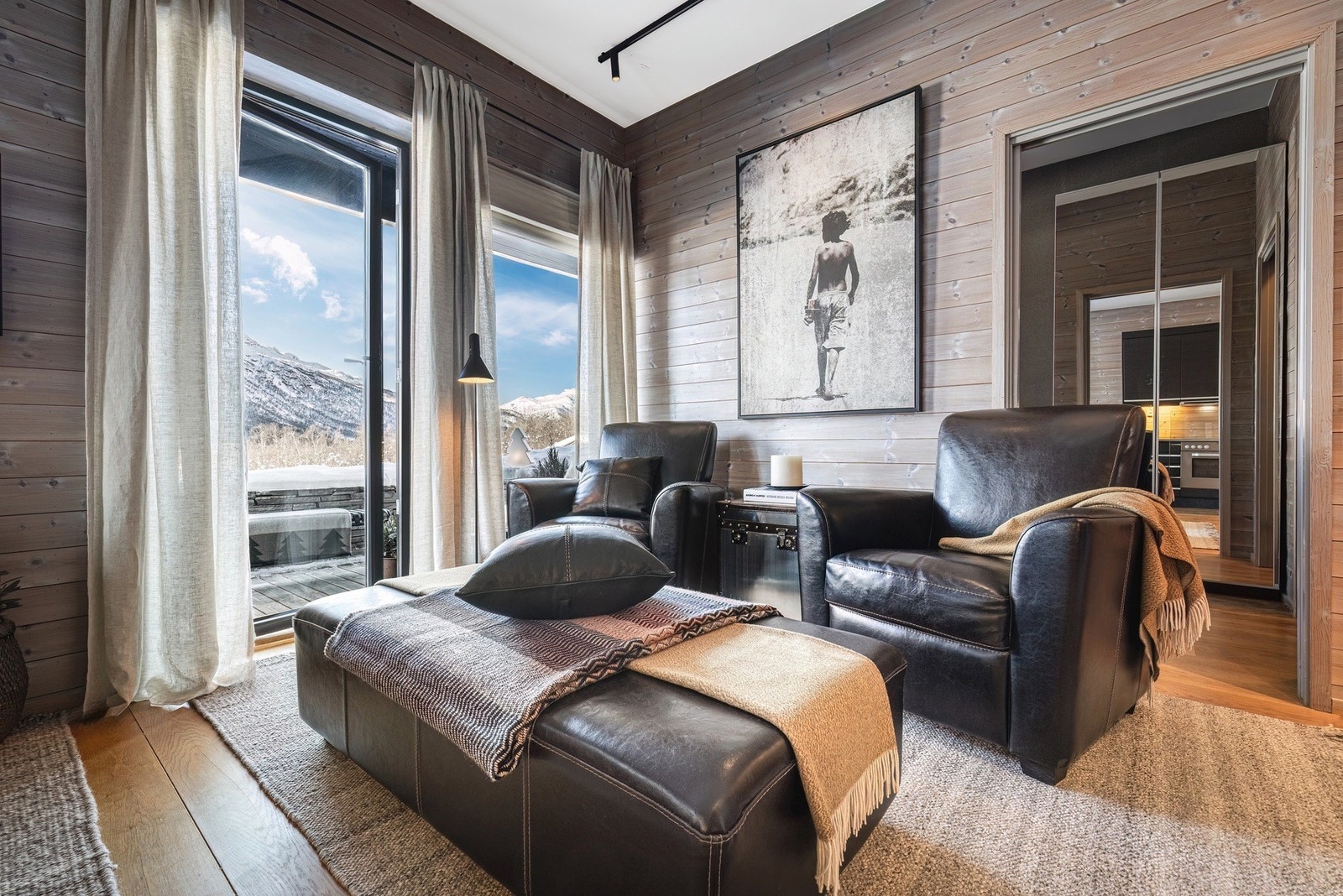 Oppholdsrommet har en luftig takhøyde, store vindusflater og en lun solrik terrasse med adkomst fra oppholdsrommet. Galleribilde