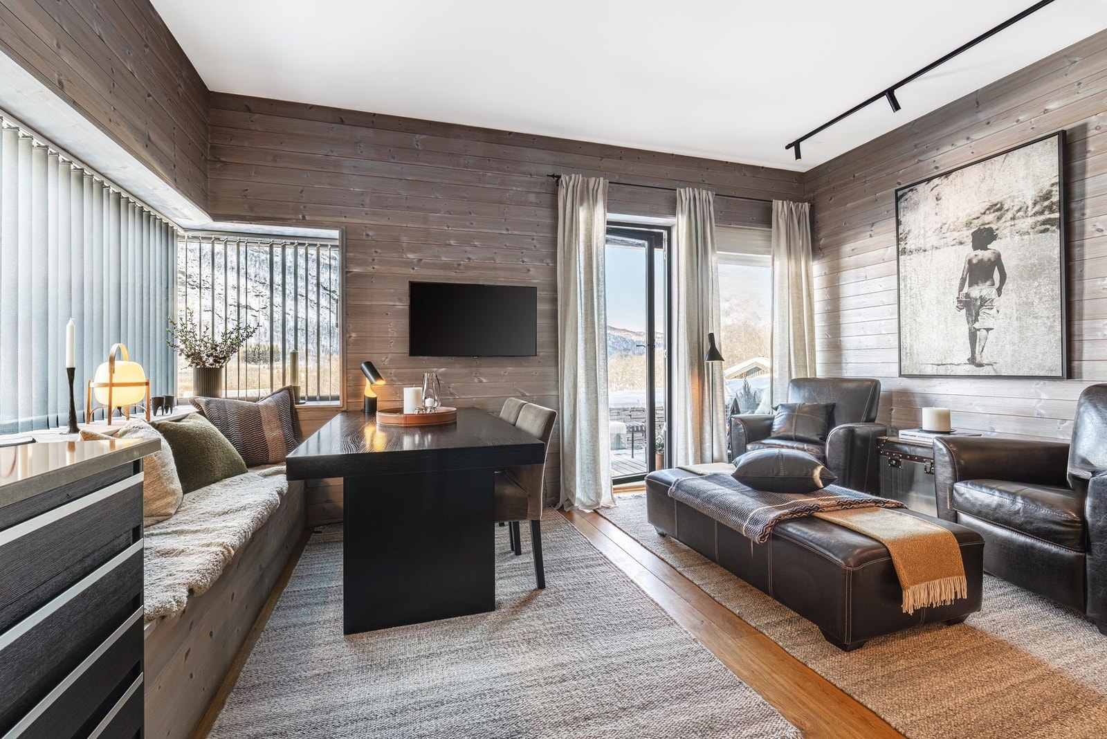 Oppholdsrommet har store vindusflater med mye naturlig dagslys. Galleribilde