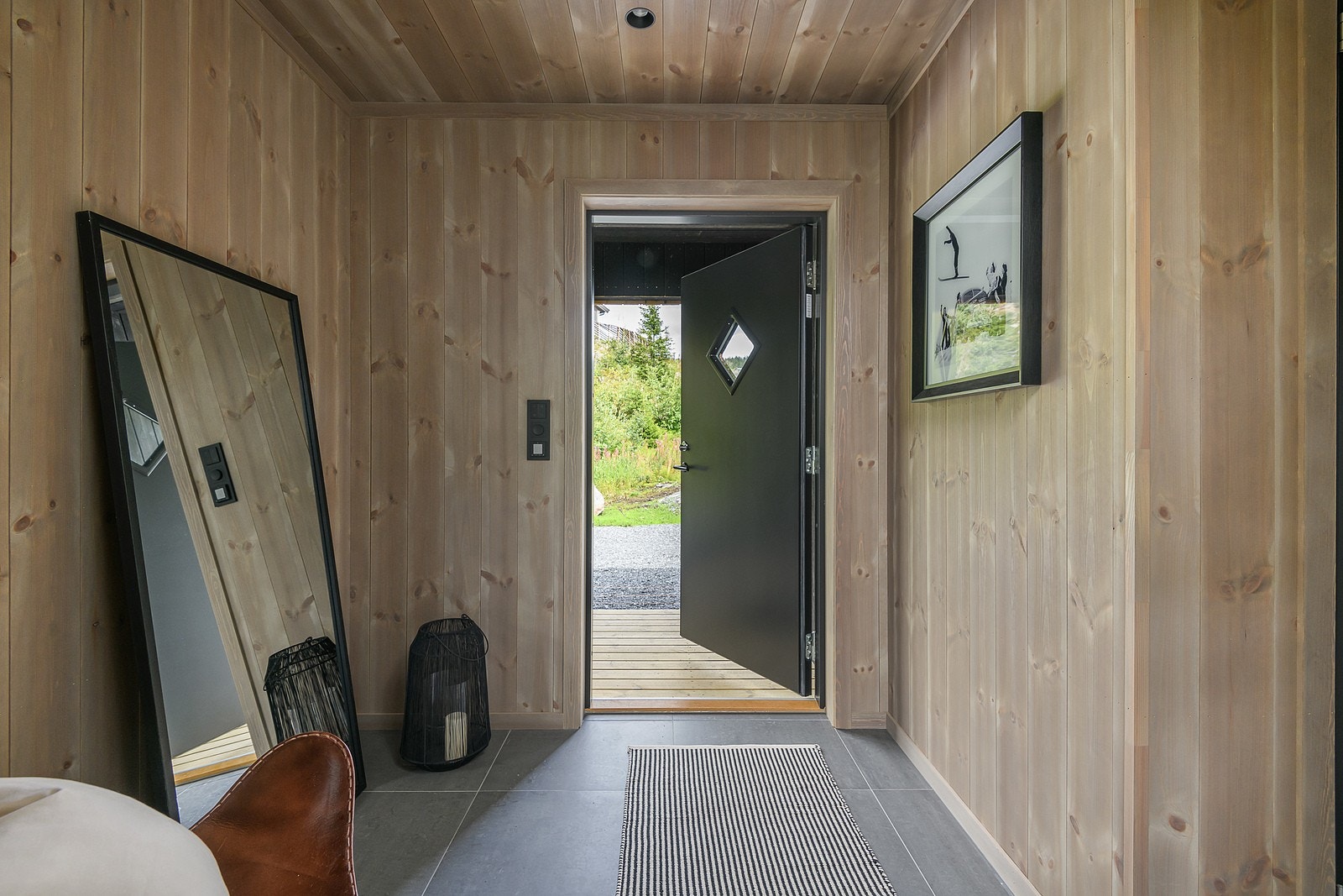 Via overbygget inngangsparti ønskes du velkommen inn i entré med god plass til å sette skoene og henge yttertøyet. Galleribilde