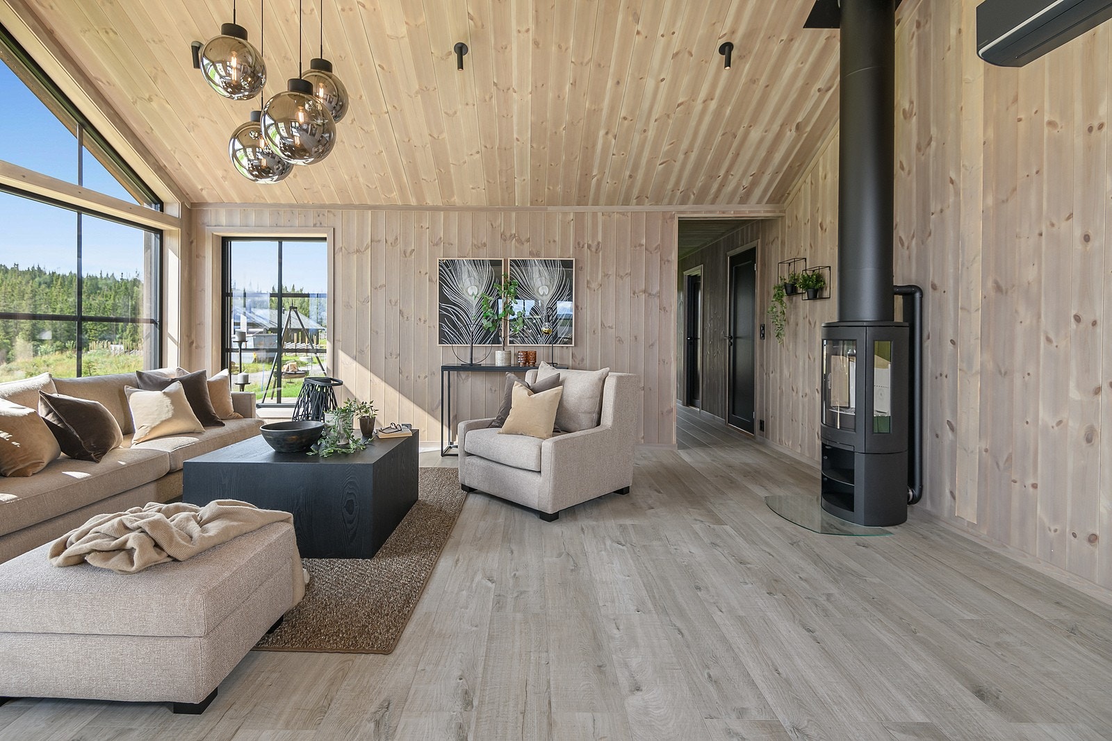 Hytta varmes opp med varmekabler i alle rom med smartstyring, varmepumpe med app-styring og vedfyring i peisovn. Galleribilde