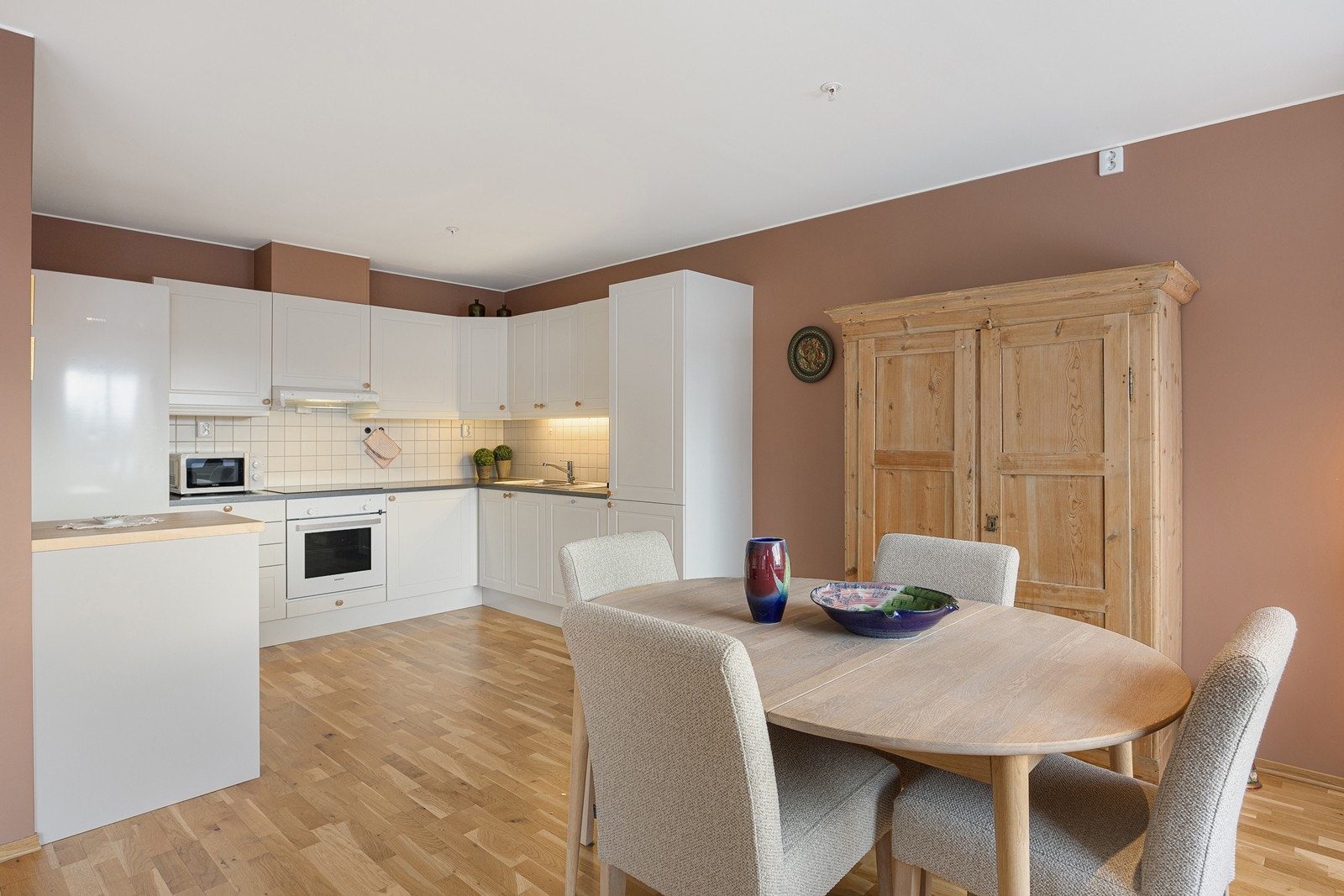 På veggene mellom benk og overskap er det fliser. Det er lys under overskapene, og det er montert både komfyrvakt og lekkasjevarsler/vanstopper. Galleribilde