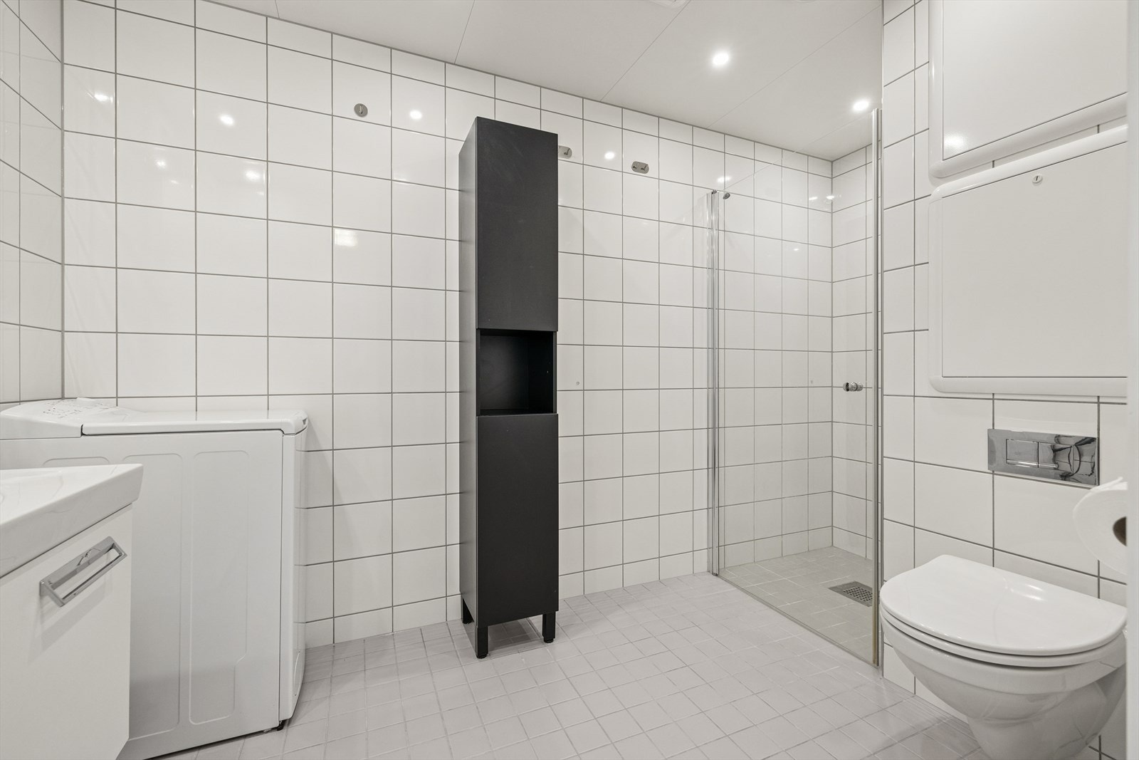 Flislagt bad med opplegg for vaskemaskin og vannbåren gulvvarme for økt komfort. Galleribilde