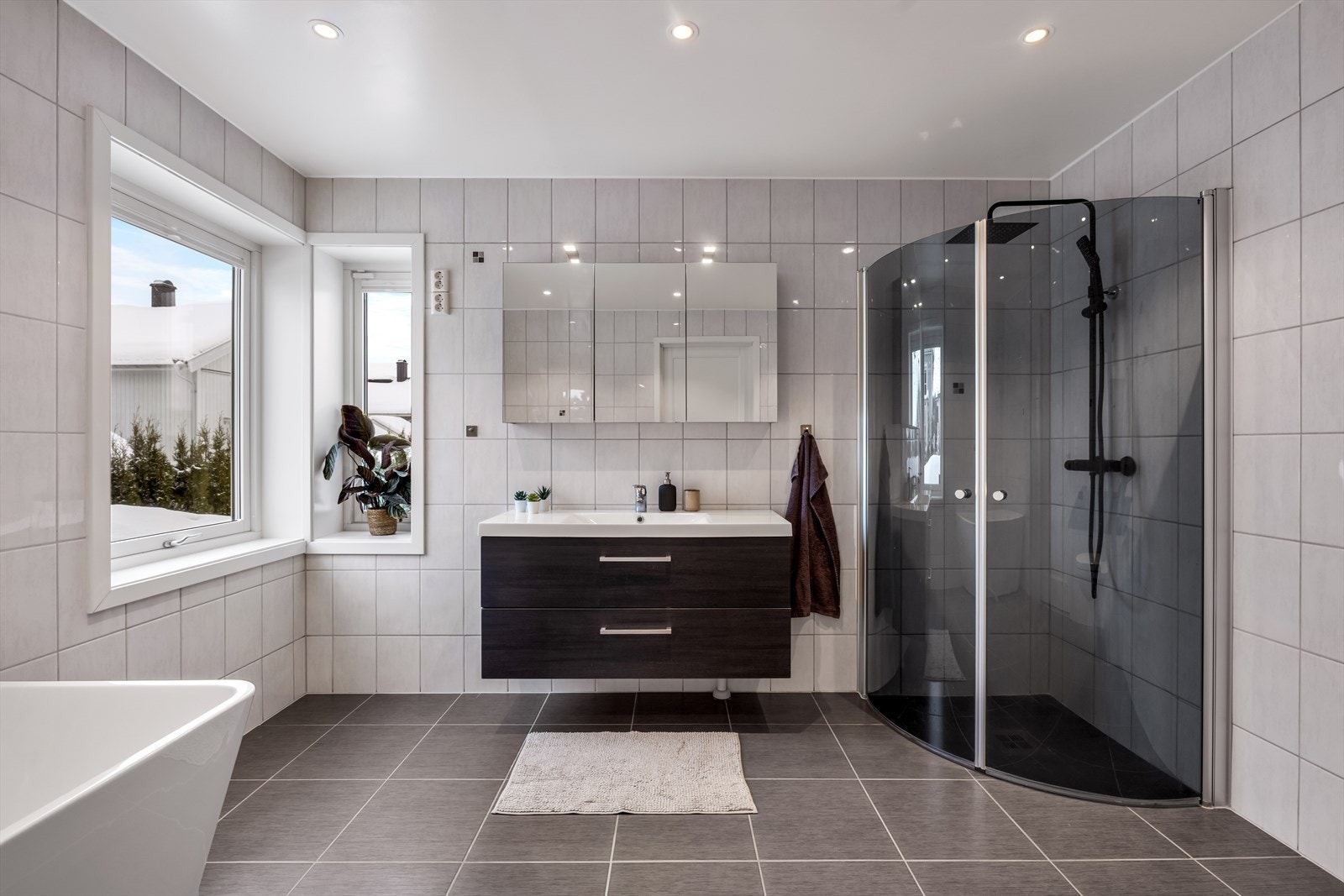 Badet har romslig løsning, flislagte overflater, gulvvarme, downlights og mekanisk avtrekk. Galleribilde