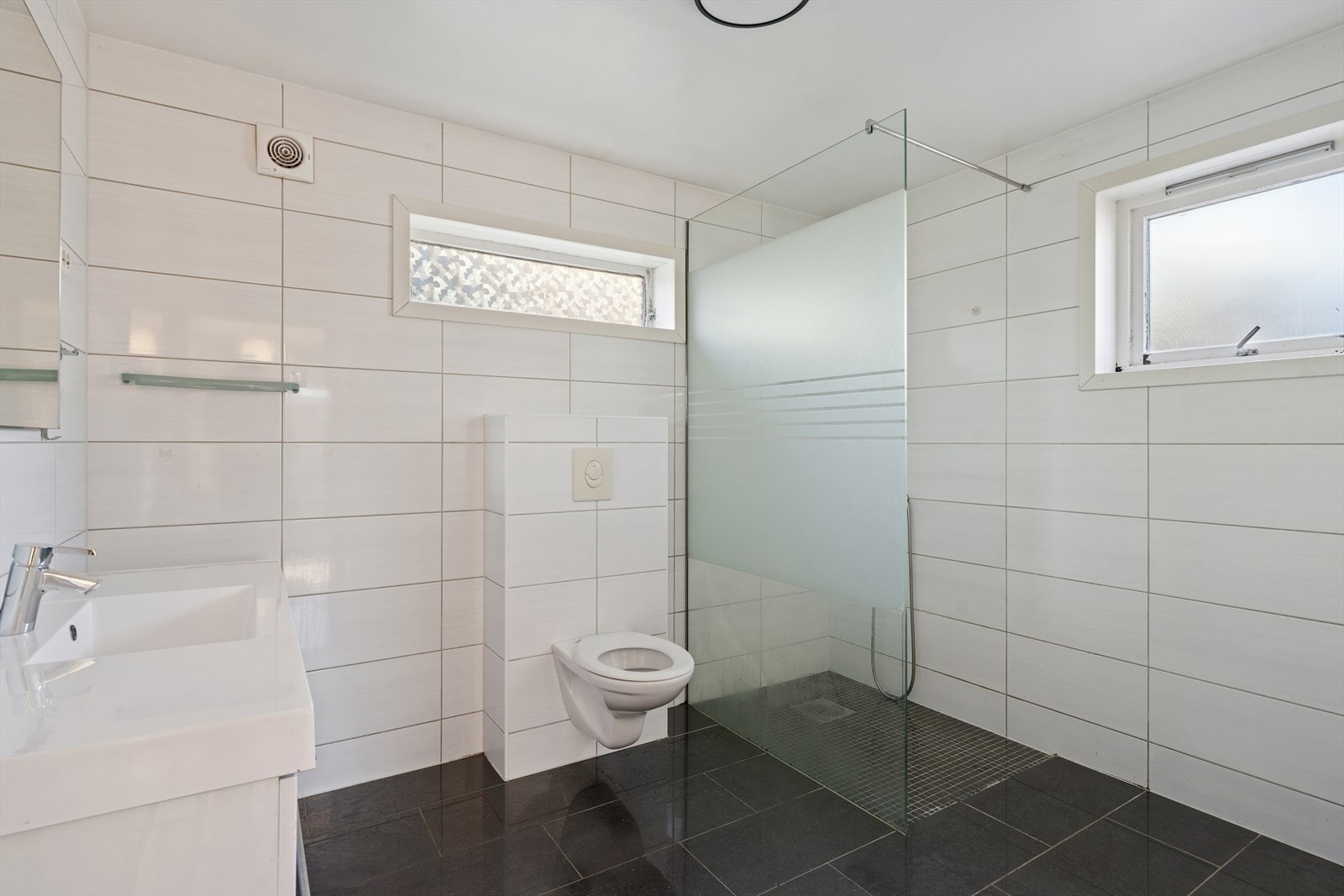 Helfliset bad med varme i gulv. Rommet ble pusset opp i perioden rundt 2011-2012, av et firma. Det finnes ikke dokumentasjon. Innredning med speil, benkeskap, servant og blandebatteri. Dusj med glassvegg. Toalett montert på vegg. Mekanisk ventilasjon. Galleribilde