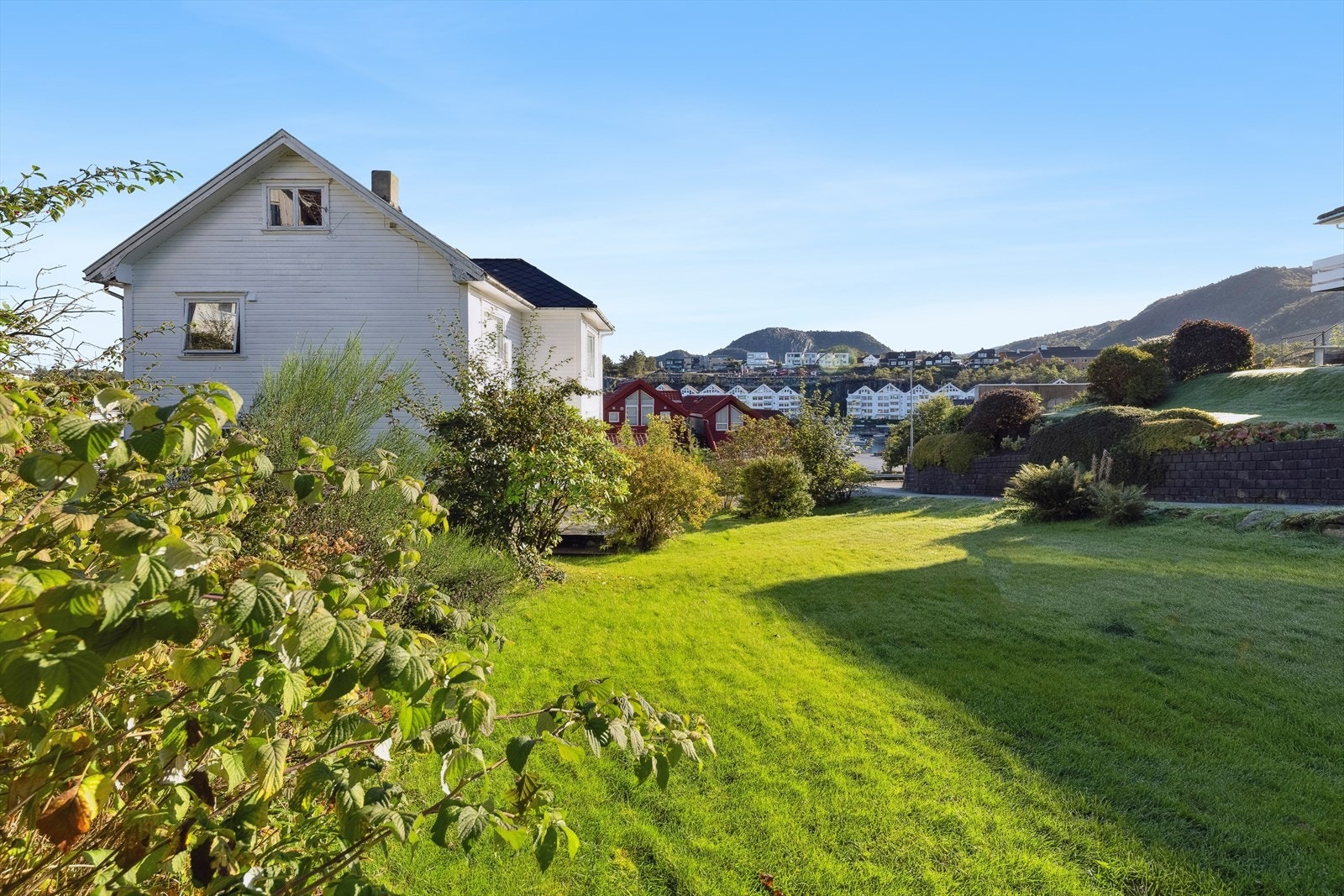 Tomten er stor, åpen og lys. Pent opparbeidet og beplantet. Solrik hage, boltreplass for både store og små. Galleribilde