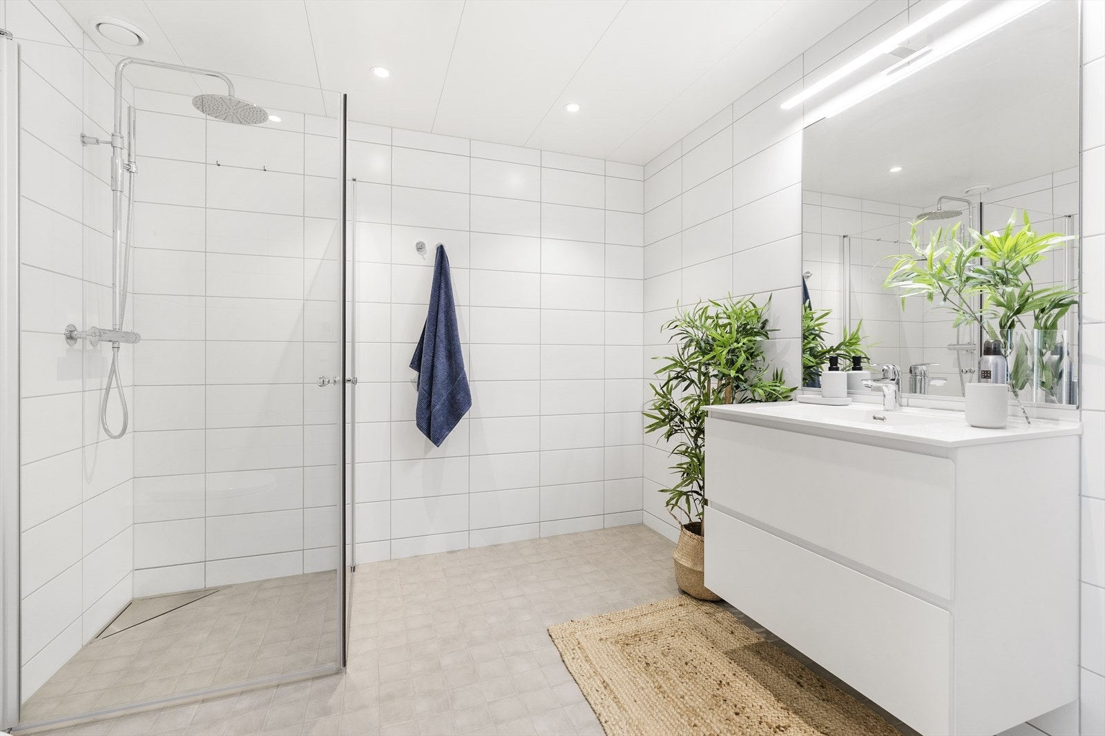 Pent helfliset bad. Det er opplegg for vaskemaskin og tørketrommel på bad. Disse er per i dag plassert mellom servant og og vegg (der hvor grønn plante står på gulvet). Galleribilde