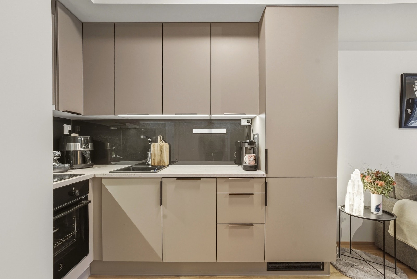 Kjøkkenet er utstyrt med integrerte hvitevarer som komfyr, oppvaskmaskin og kjøleskap, som bidrar til en sømløs og moderne estetikk. Galleribilde