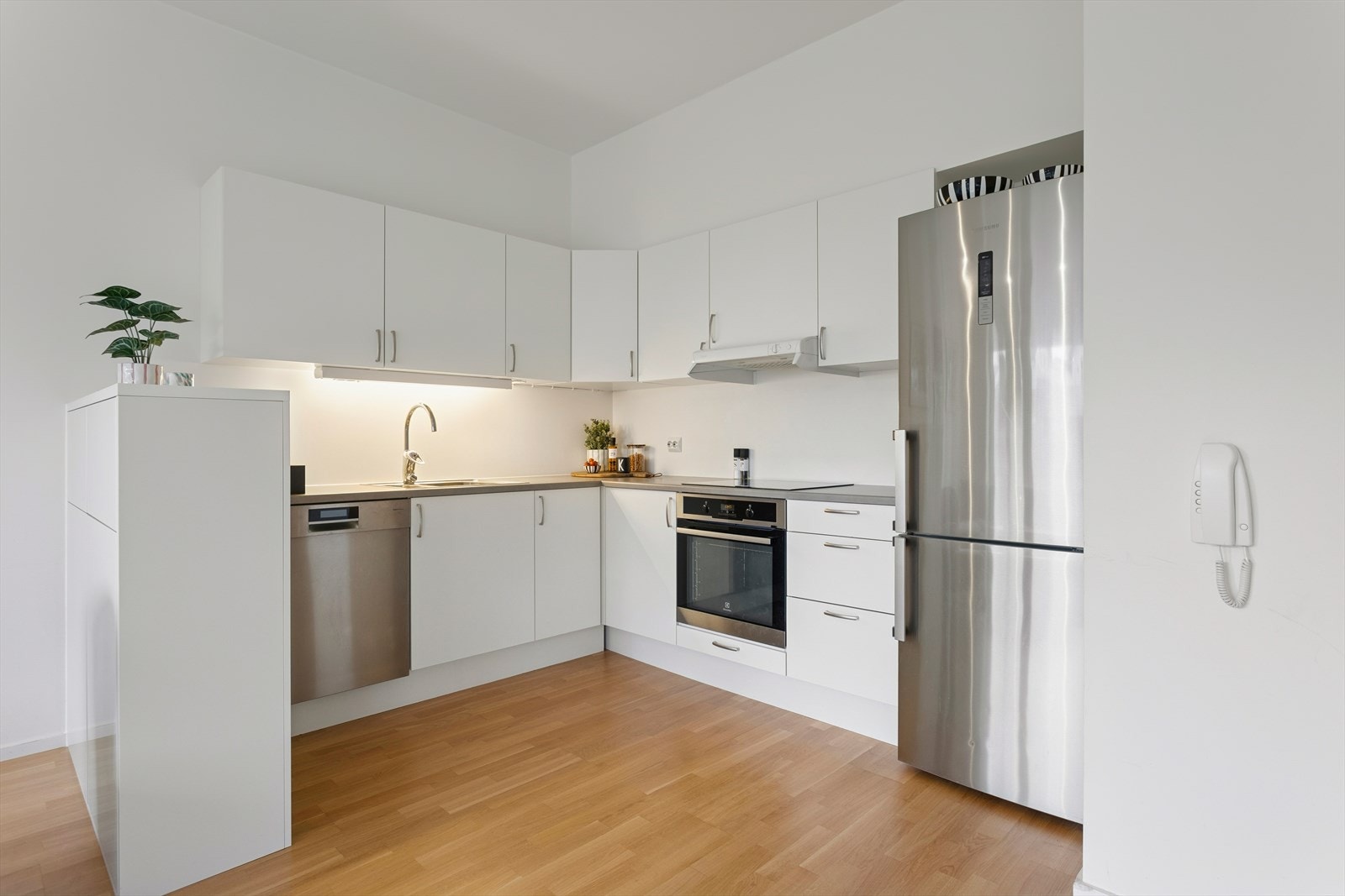 Kjøkkenet har hvite, slette fronter og er godt utstyrt med skap- og benkeplass. Alle hvitevarene medfølger handelen som: Integrert komfyr, platetopp, oppvaskmaskin og frittstående kjøleskap. Galleribilde