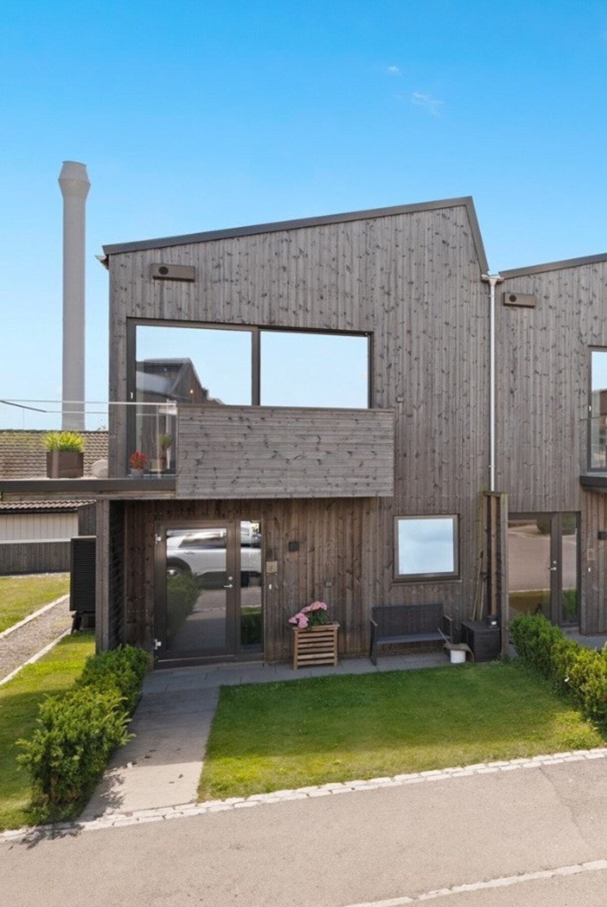 På fremsiden av bygget er det grønn plen og hyggelig uteplass. Galleribilde