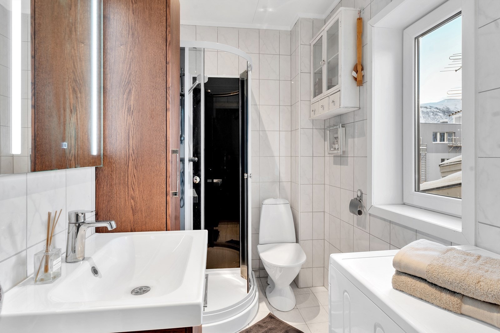 Komplett flislagt bad med praktiske innredninger og opplegg for vaskemaskin. Galleribilde