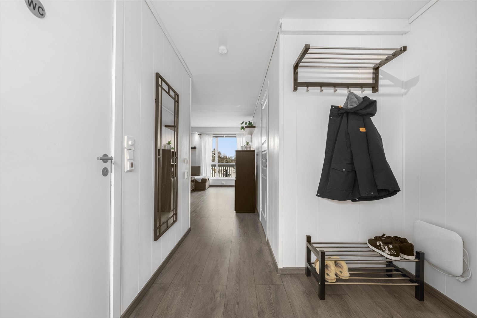 Fra gangen er det direkte tilgang til leilighetens øvrige rom, med enhetlig laminatgulv som binder sonene sammen. Galleribilde