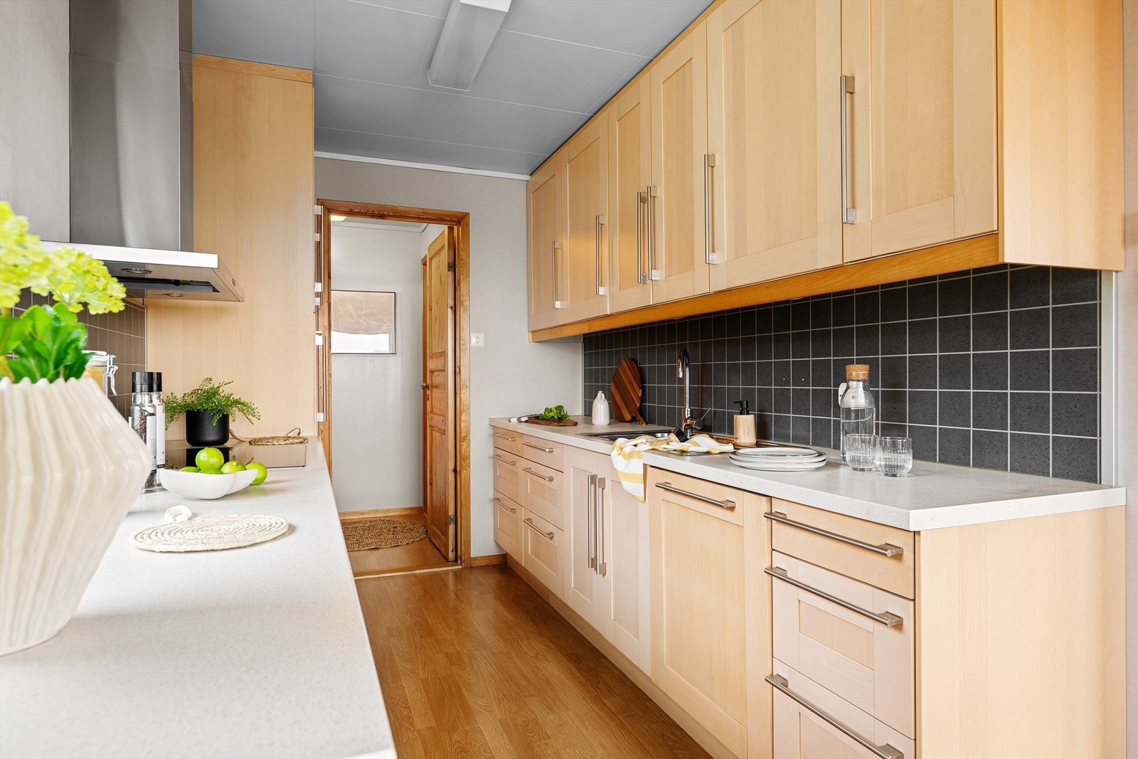 Kjøkkenet har innredning med profilerte fronter. Benkeplaten er av laminat. Det er kjøleskap, oppvaskmaskin, platetopp og stekeovn. Galleribilde