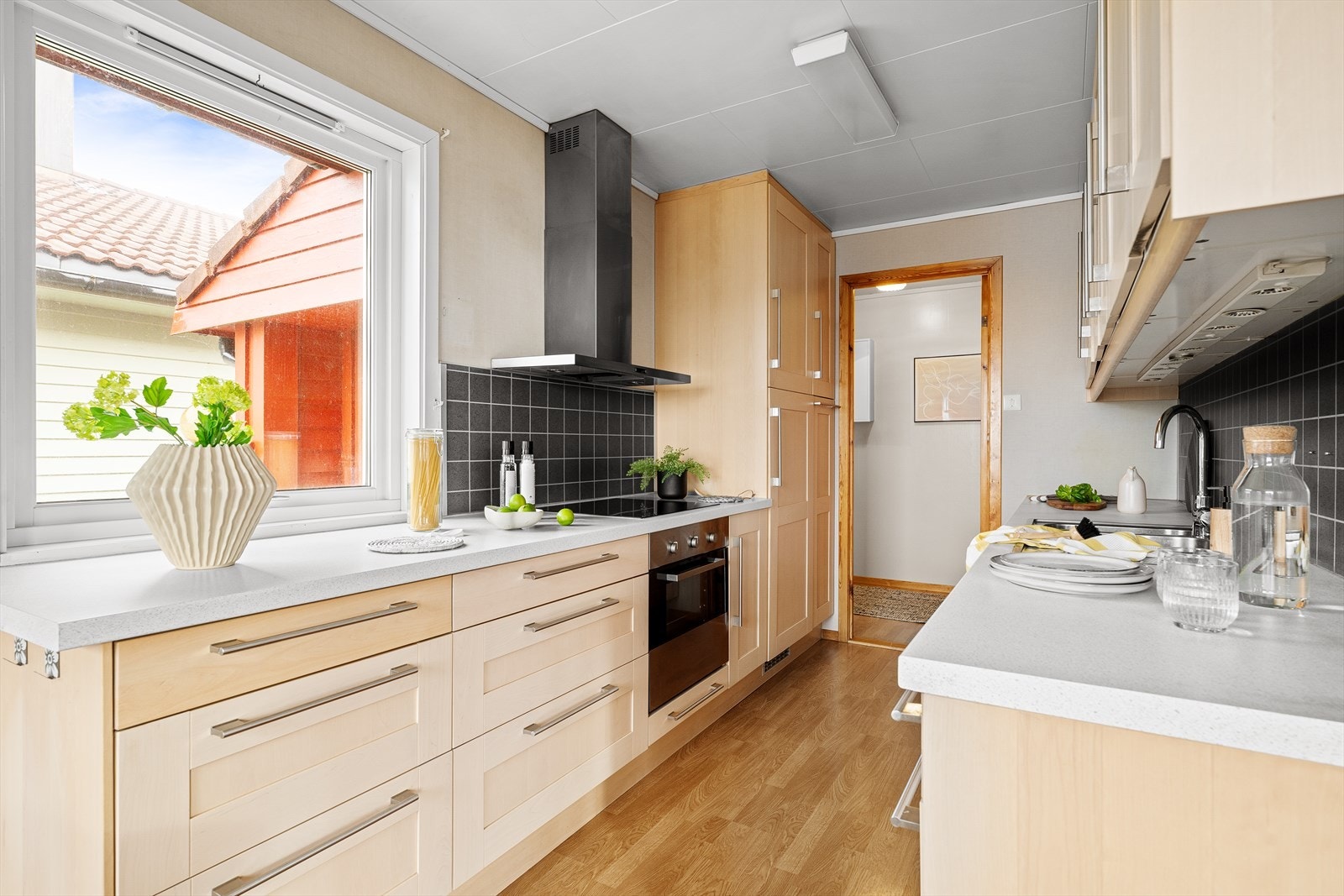 Kjøkkenet har innredning med profilerte fronter. Benkeplaten er av laminat. Det er kjøleskap, oppvaskmaskin, platetopp og stekeovn. Galleribilde