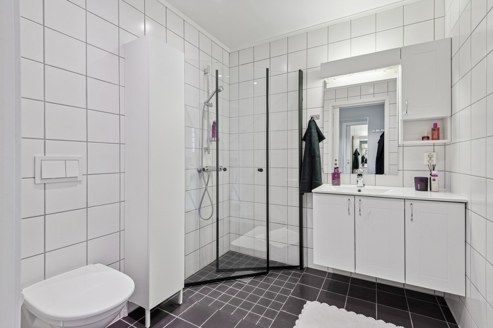 Flislagt bad med varme i gulv. Vegghengt toalett og dusjhjørne. Galleribilde