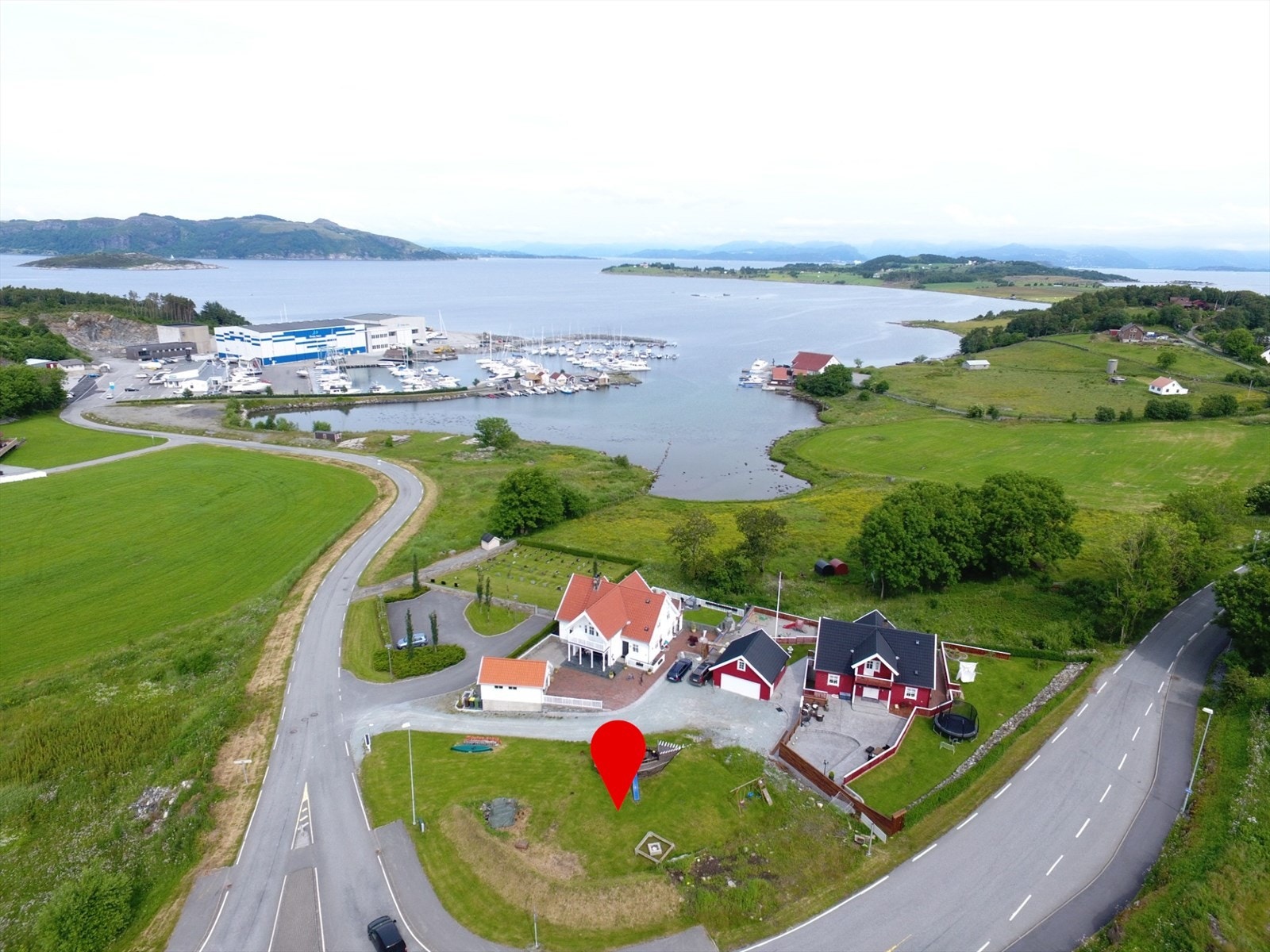 Her presenteres en stor tomt med en flott beliggenhet i meget naturskjønne omgivelser på Vestre Åmøy. Foto: Dirdal Foto v/Stian Dirdal. Felles lekeplass i mellom de to bebygde husene. Galleribilde