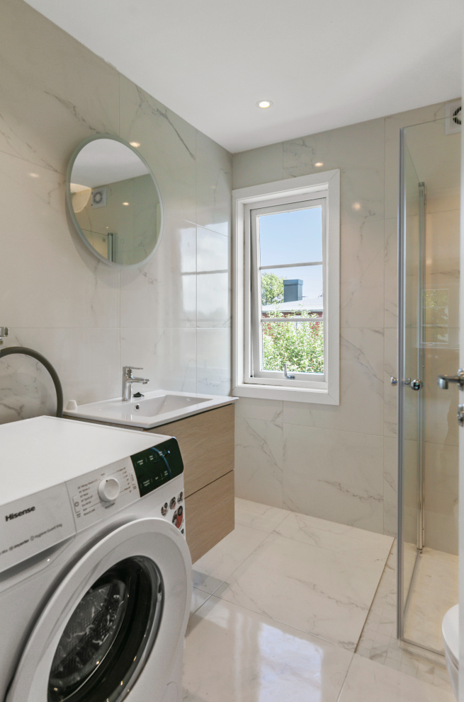 Badet har vaskemaskin, dusj, servant og wc Galleribilde