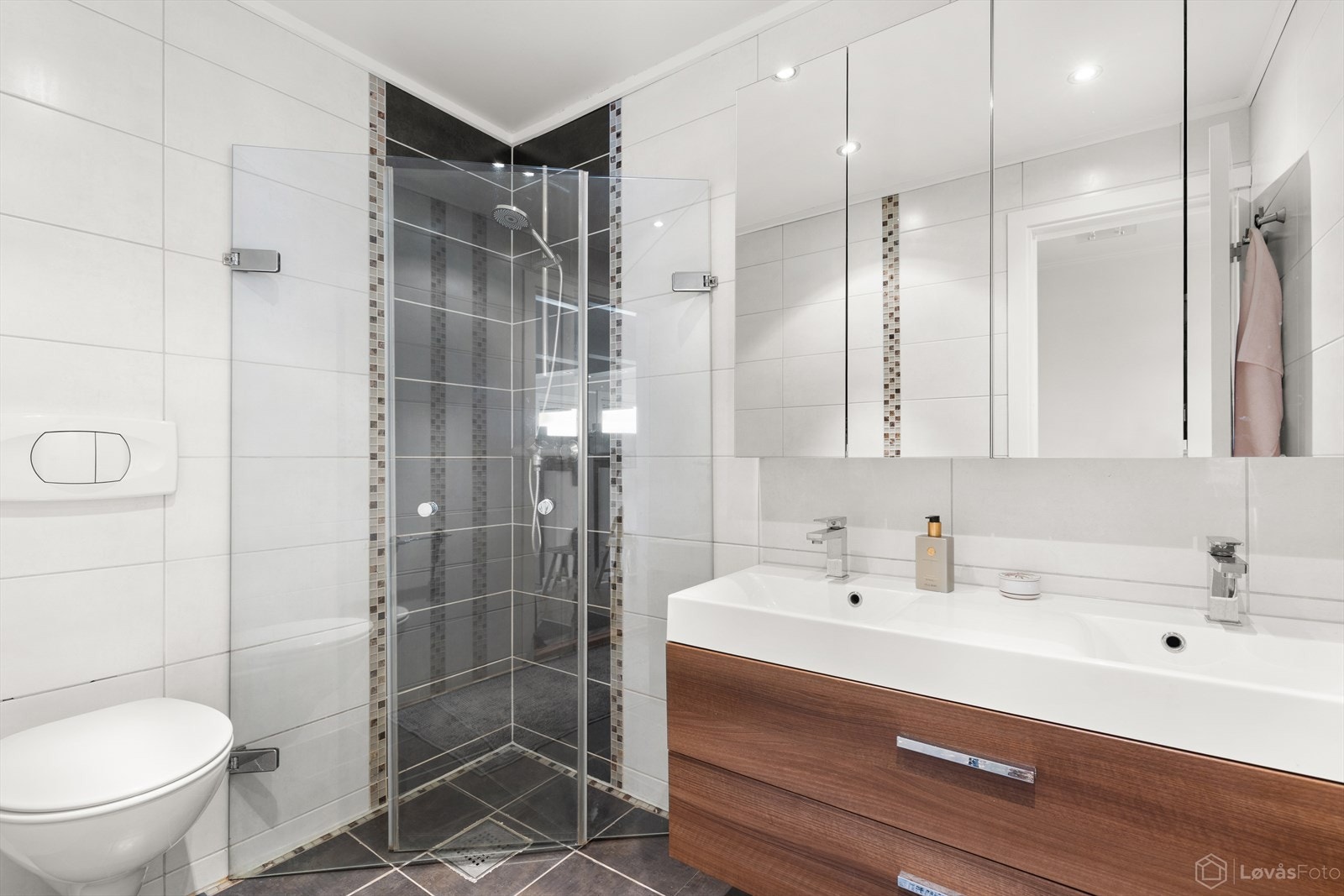 Lekkert bad med dusjhjørne, dobbel servant og speilskap med oppbevaringsplass. Galleribilde