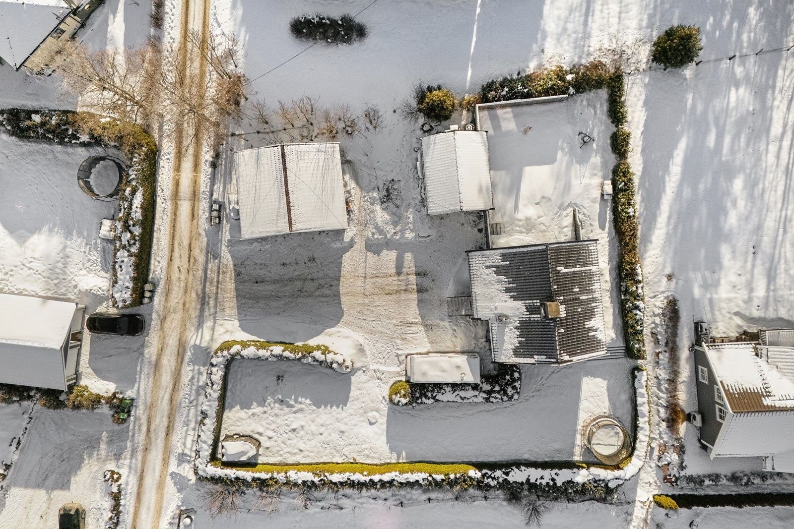 Eiendommen er pent opparbeidet med gressplen og beplantning. Deler av tomten er innrammet med hekker som skjermer mot innsyn fra naboer og forbipasserende. Gruset gårdsplass med biloppstillingsplass for flere biler. Galleribilde