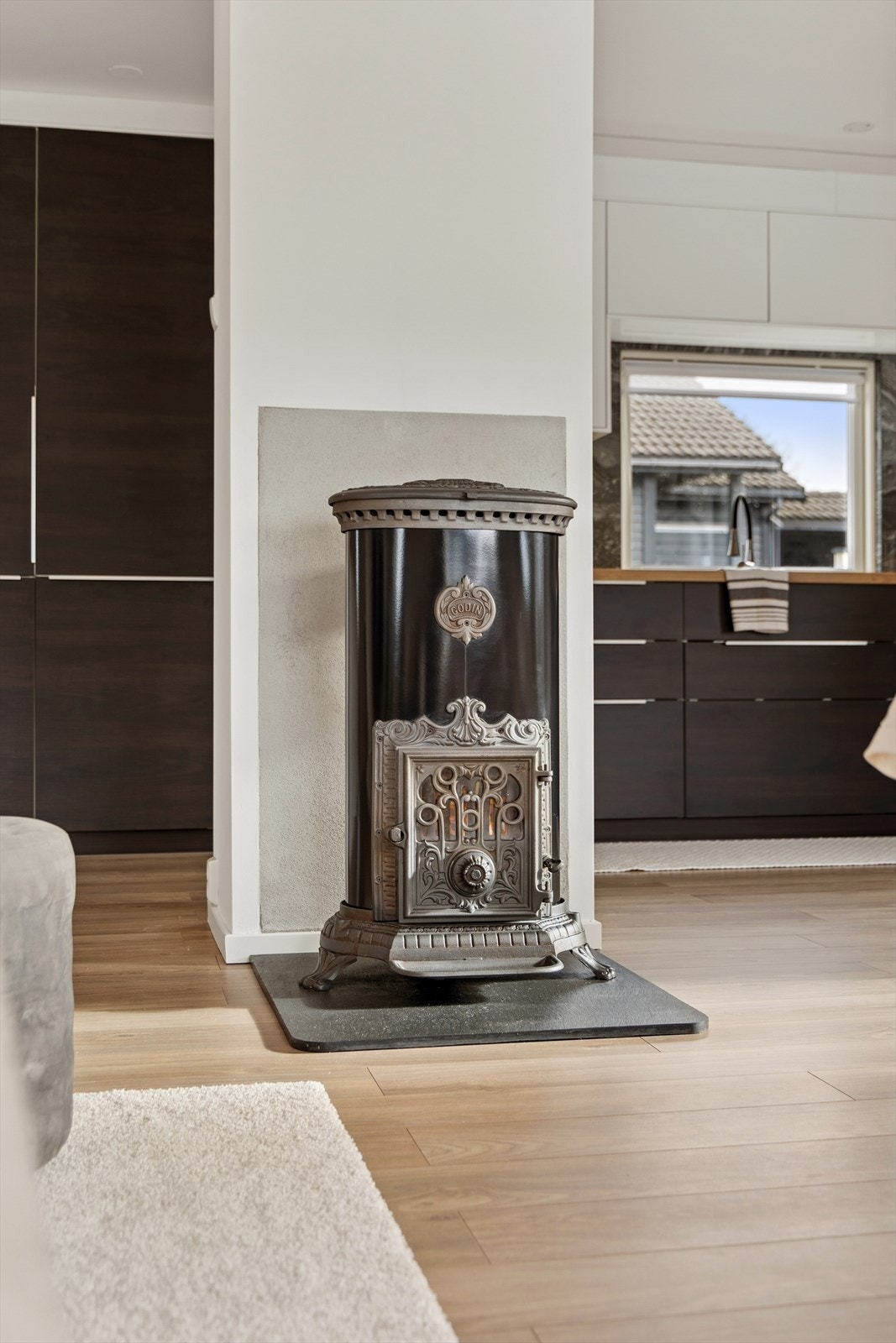 En vedovn som er plassert mellom stue og kjøkken sørger for effektiv oppvarming og skaper en varm, hyggelig atmosfære på kalde dager. Galleribilde