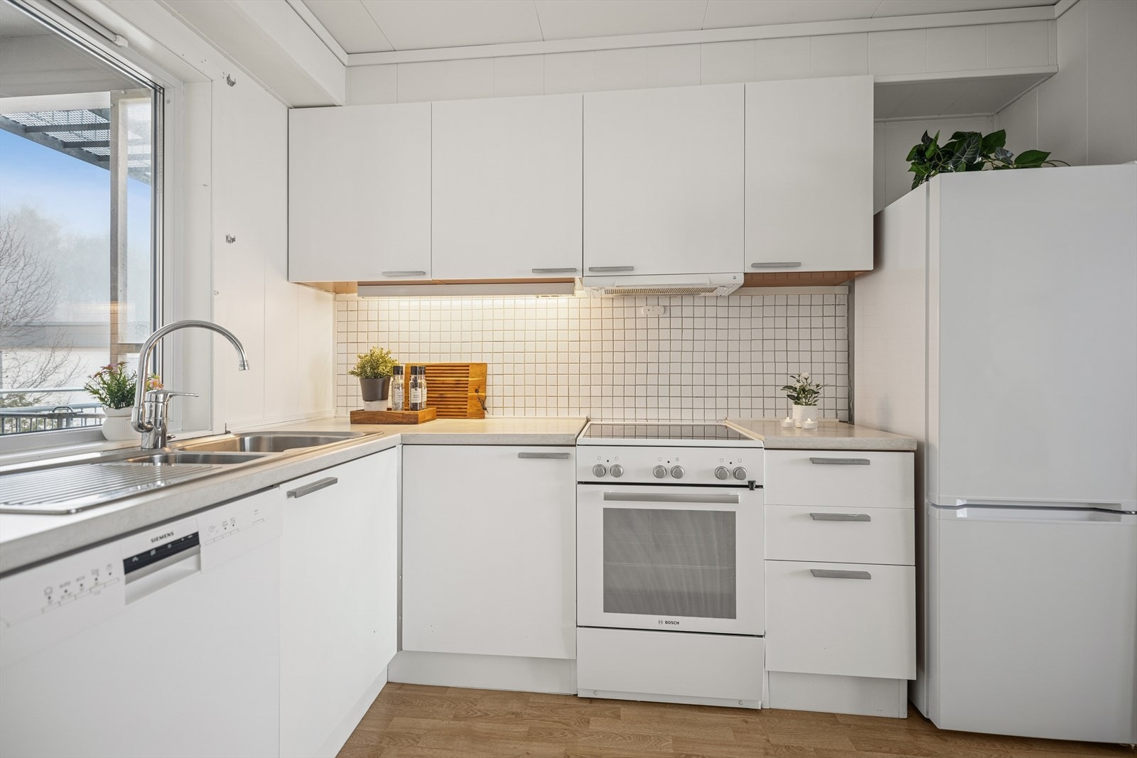 Kjøkkeninnredningen er fra Aran med hvitmalte fronter og laminat benkeplate. Oppvaskmaskin og komfyr medfølger. Kjøleskap kan følge etter avtale. Galleribilde