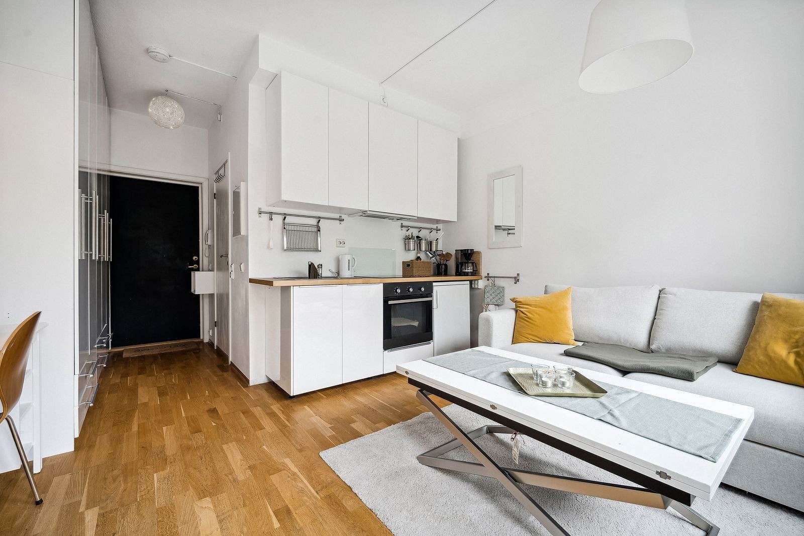 En lys og åpen stue med plassbygde møbler som gir maksimal utnyttelse av plassen. Galleribilde