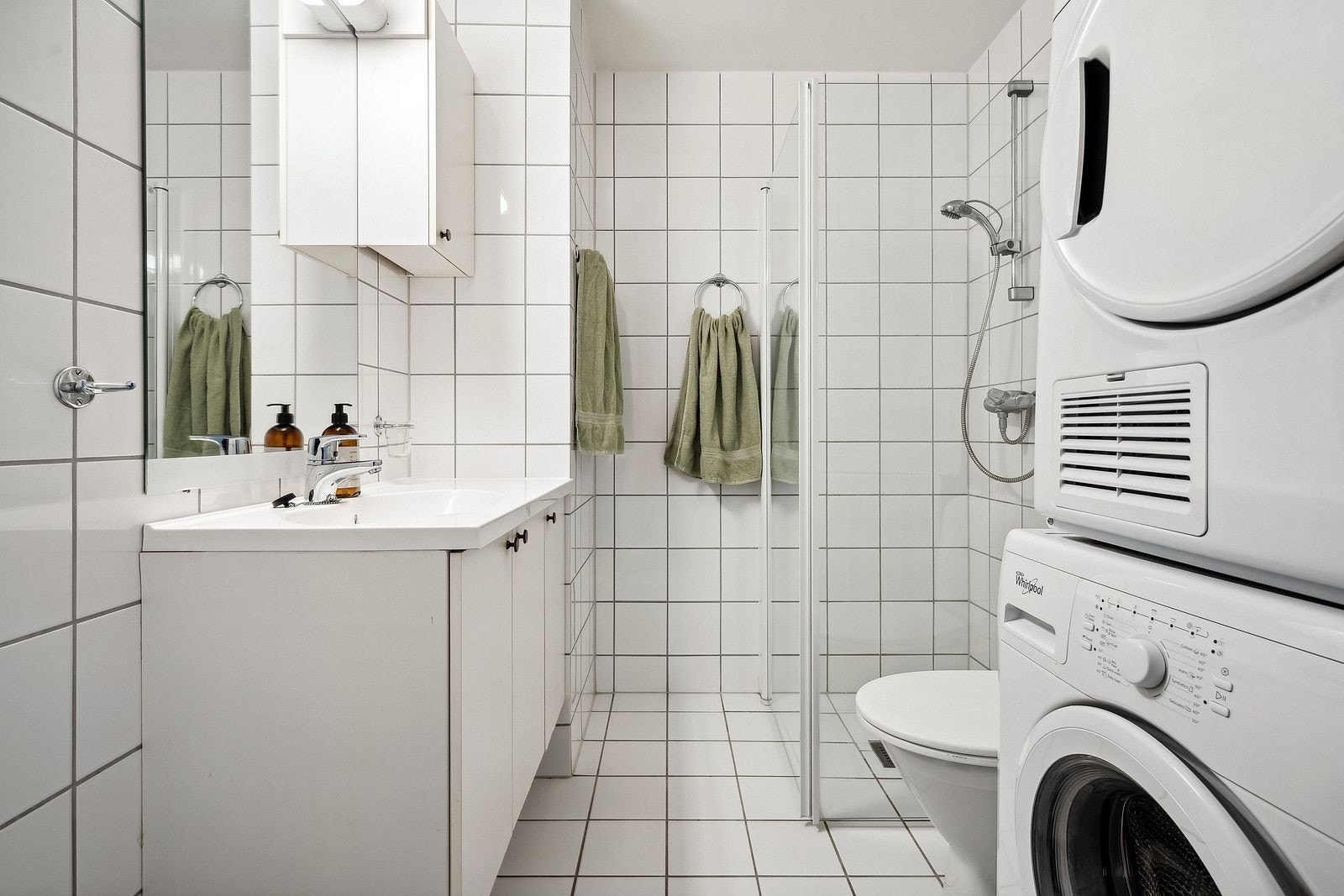 Flislagt baderom med gulvvarme, vaskemaskin og tørketrommel. Galleribilde